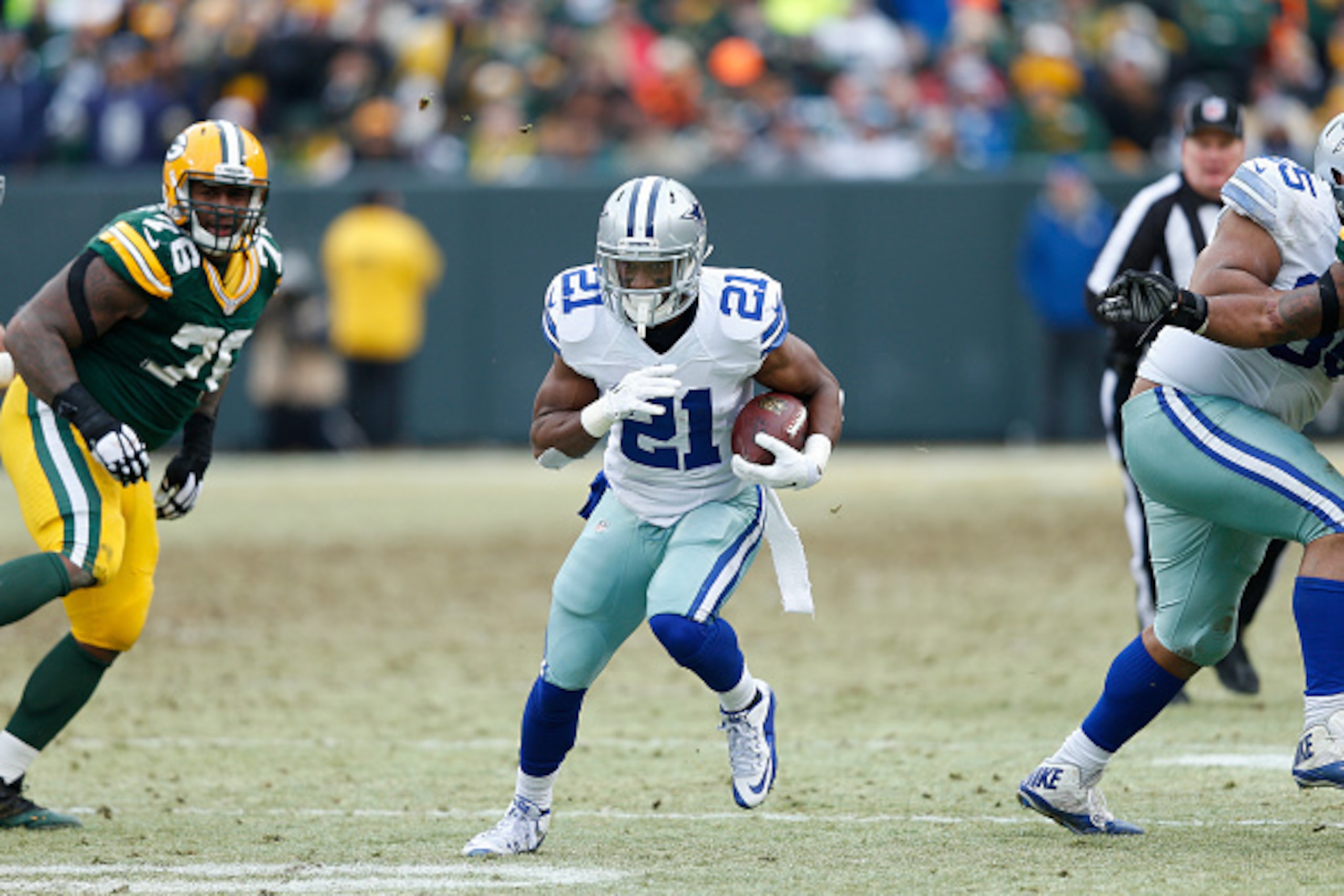 GREEN BAY, WI - JANUARY 11: Joseph Randle #21 of the Dallas Cowboys runs with the ball against the Green Bay Packers during the NFC Divisional Playoff game at Lambeau Field on January 11, 2015 in Green Bay, Wisconsin. The Packers defeated the Cowboys 26-2
