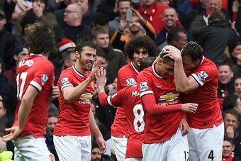 Manchester United's English defender Chris Smalling (2nd R) celebrates with teammates after scoring their fourth goal during the English Premier League football match between Manchester United and Manchester City at Old Trafford in Manchester, north west 