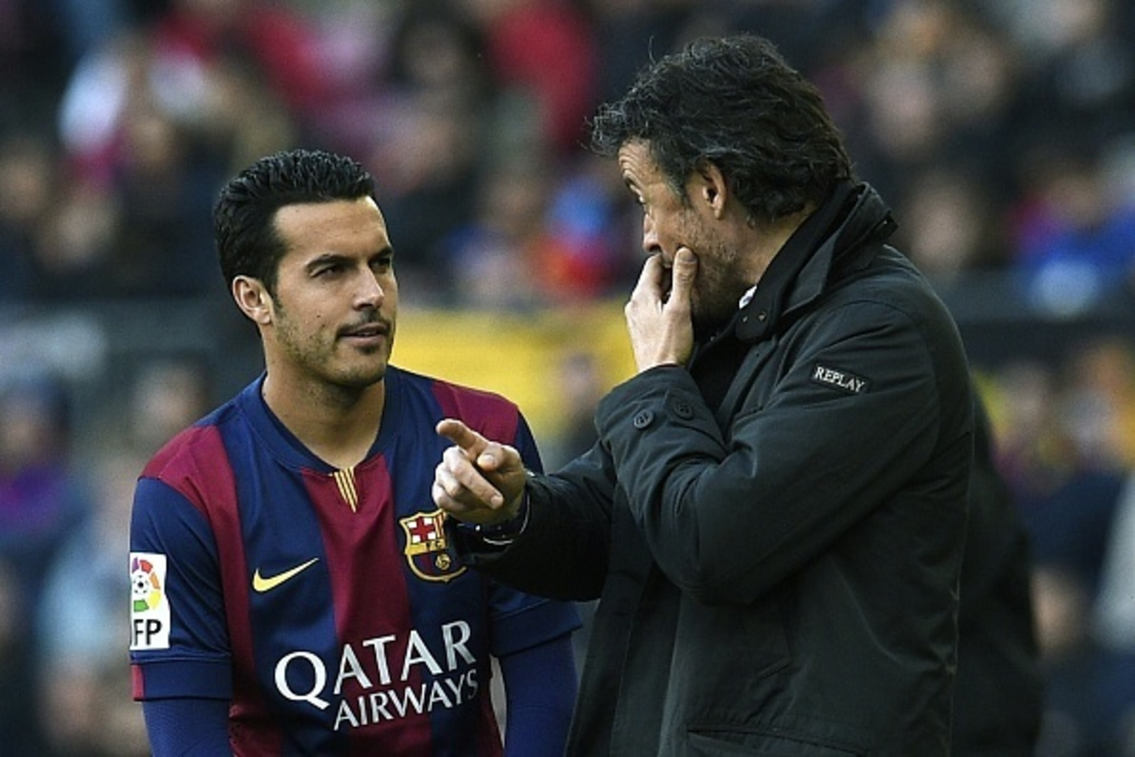 Barcelona's coach Luis Enrique (R) talls with Barcelona's forward Pedro Rodriguez (L) during the Spanish league football match FC Barcelona vs Malaga CF at the Camp Nou stadium in Barcelona on February 21, 2015. AFP PHOTO / LLUIS GENE        (Photo credit