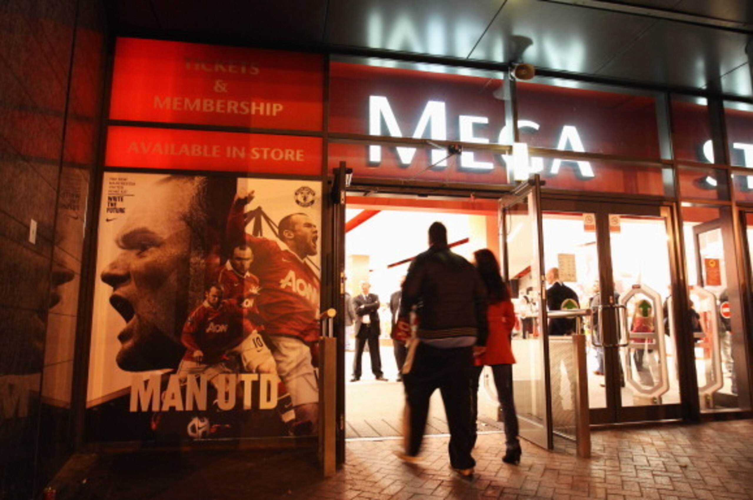 MANCHESTER, ENGLAND - OCTOBER 20: Manchester United fans walk past a Wayne Rooney display at the megastore prior to the UEFA Champions League Group C match between Manchester United and Bursaspor Kulubu at Old Trafford on October 20, 2010 in Manchester, MANCHESTER, ENGLAND - OCTOBER 20: Manchester United fans walk past a Wayne Rooney display at the megastore prior to the UEFA Champions League Group C match between Manchester United and Bursaspor Kulubu at Old Trafford on October 20, 2010 in Manchester,