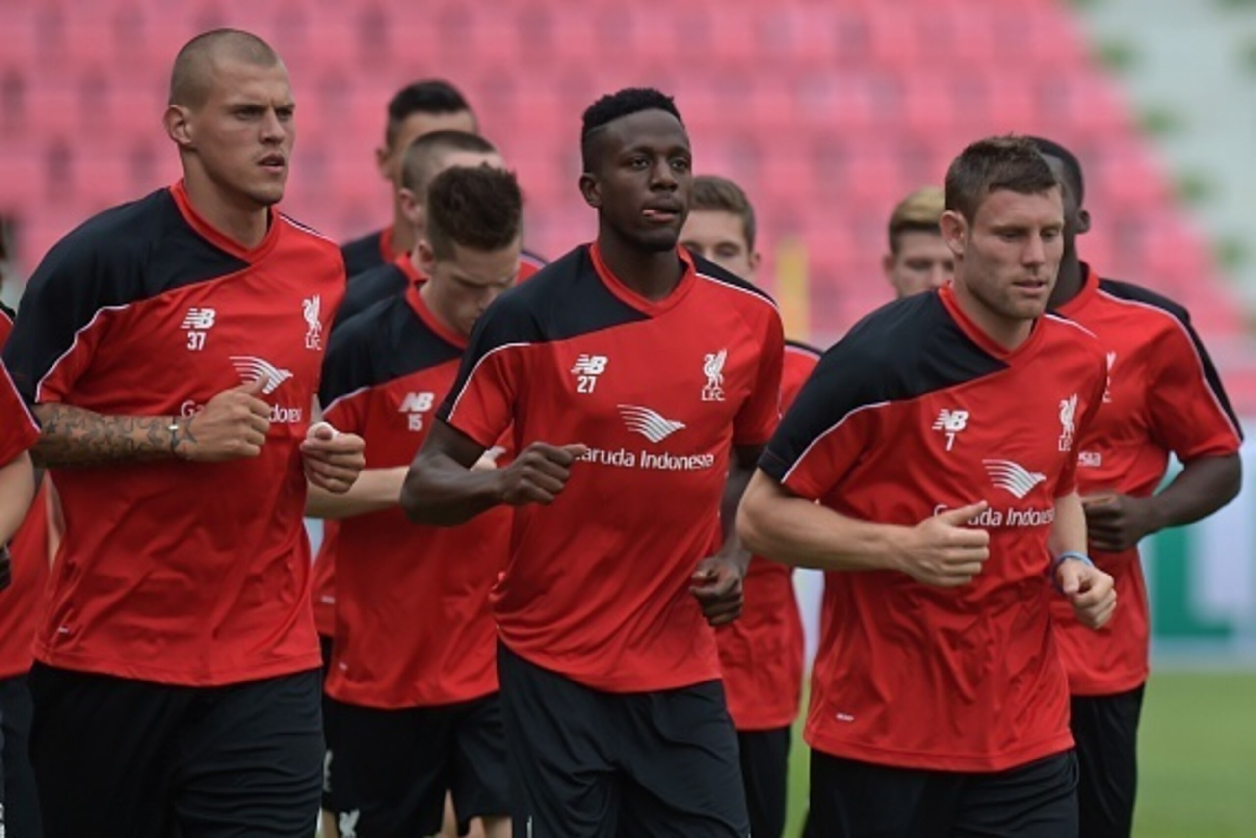 Liverpool football players James Milner (R) Divock Origi (C) and Martin Skrtel (L) warm-up during a team training session at Rajamangala stadium in Bangkok on July 13, 2015. Liverpool football team will play an exhibition match with Thai Premier League Al