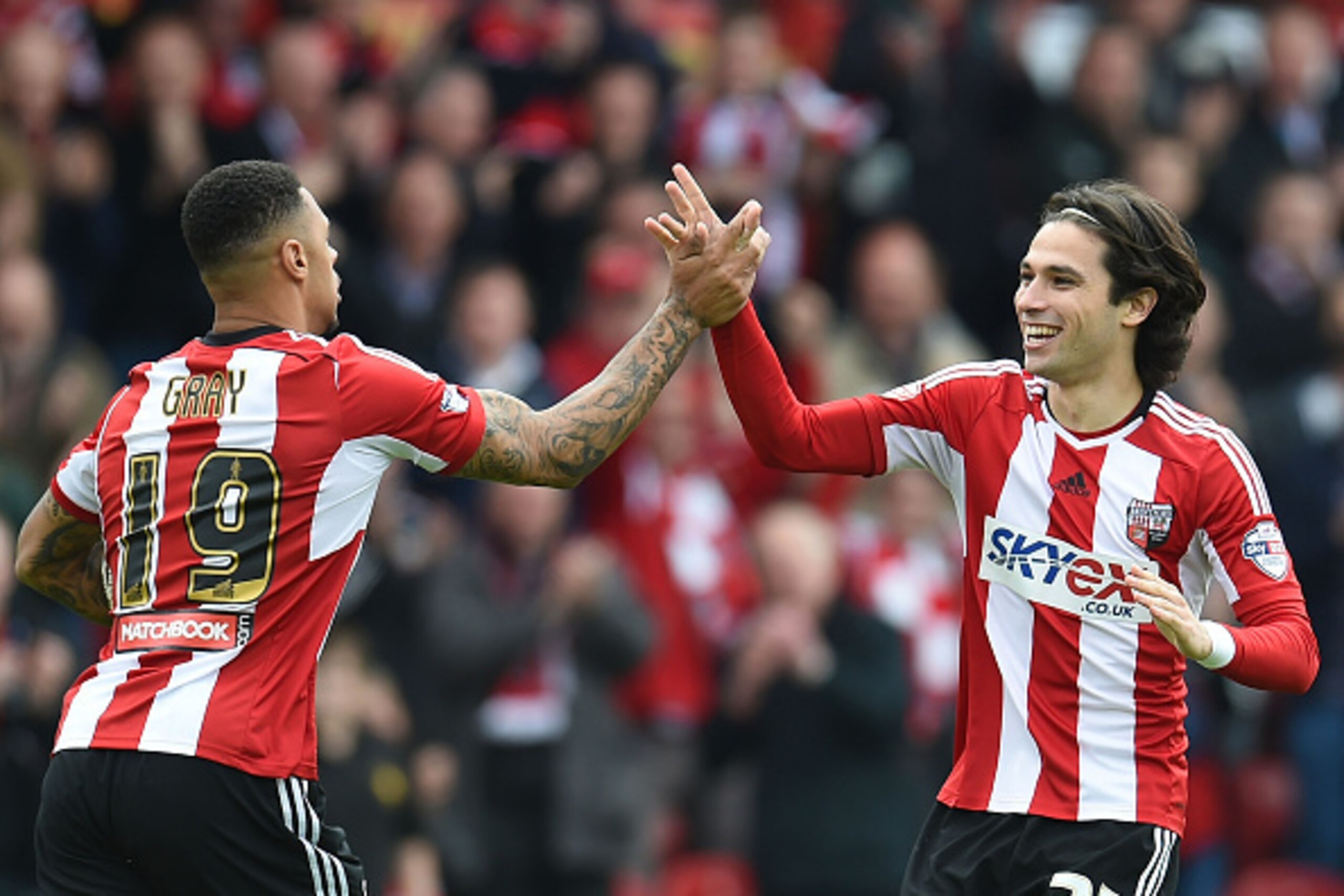 BRENTFORD, ENGLAND - MAY 02: Jota (R) of Brentford celebrates scoring his goal with Andre Gray (L) during the Sky Bet Championship match between Brentford and Wigan Athletic at Griffin Park on May 2, 2015 in Brentford, England.  (Photo by Tom Dulat/Getty 