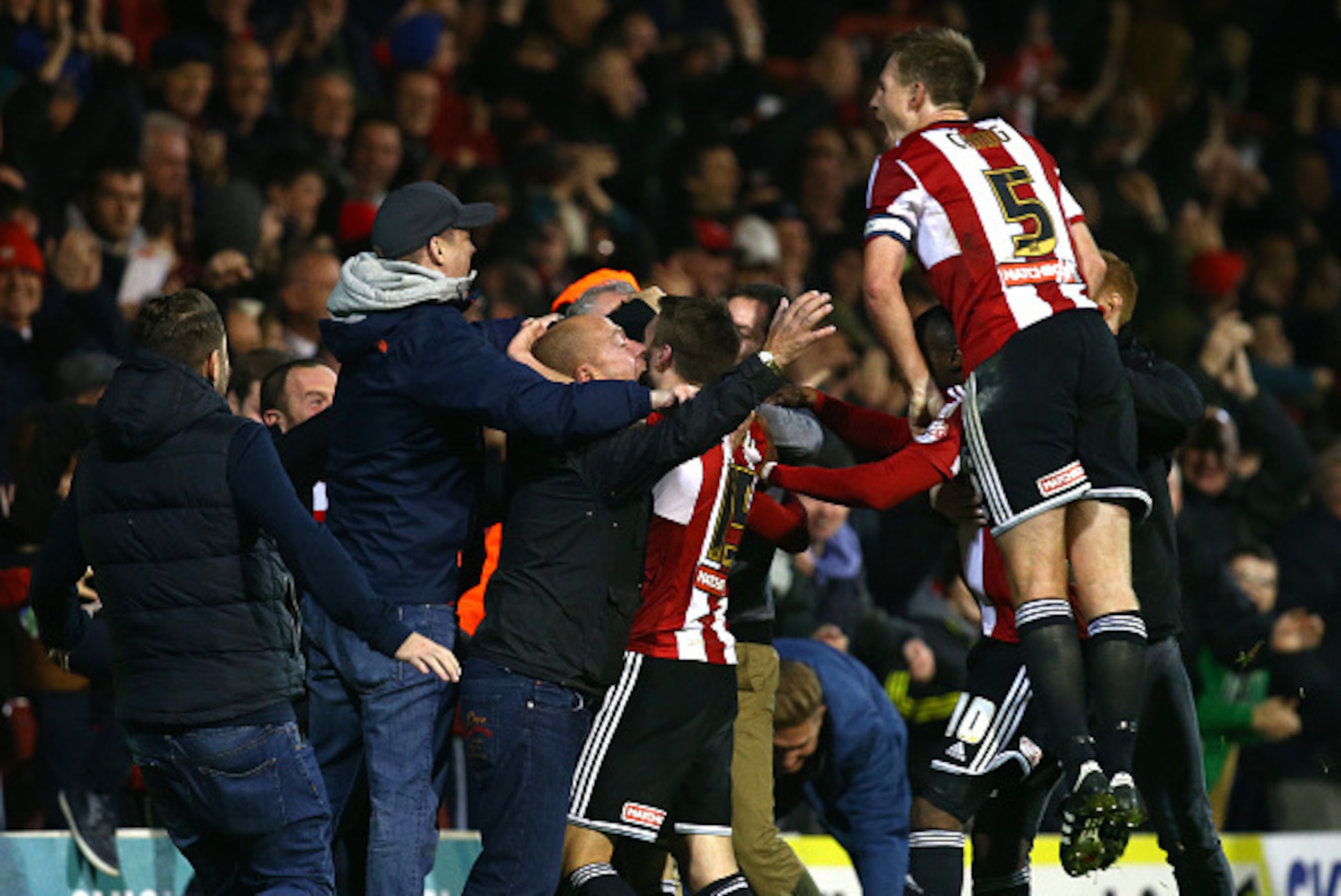 BRENTFORD, ENGLAND - NOVEMBER 21: Jota of Brentford celebrates with team mates and fans after scoring winning goal late on during the Sky Bet Championship match between Brentford and Fulham at Griffin Park on November 21, 2014 in Brentford, England, (Phot