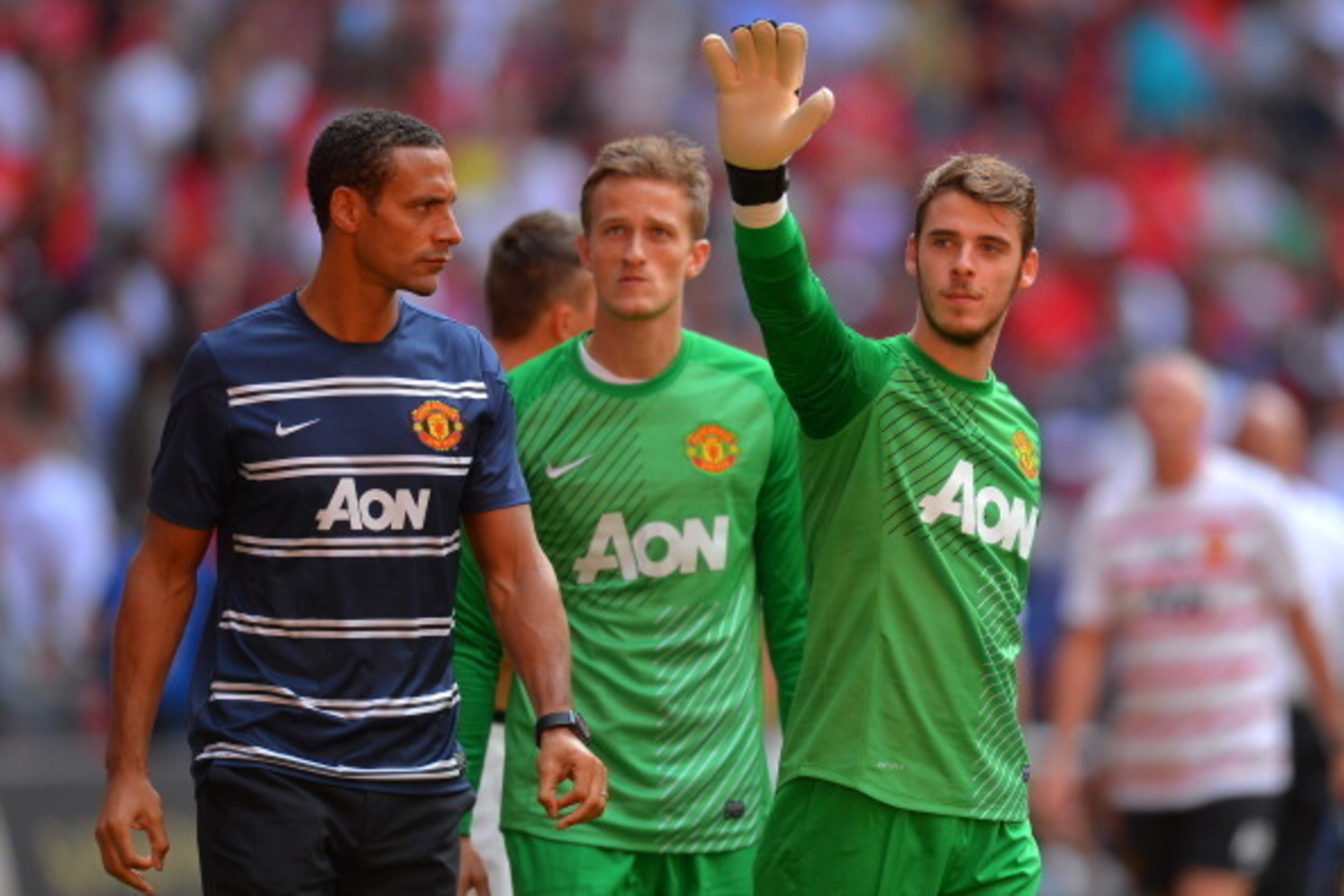 LONDON, ENGLAND - AUGUST 11: Rio Ferdinand of Manchester United looks on as team mate David De Gea waves to fans after victory in the FA Community Shield match between Manchester United and Wigan Athletic at Wembley Stadium on August 11, 2013 in London, LONDON, ENGLAND - AUGUST 11: Rio Ferdinand of Manchester United looks on as team mate David De Gea waves to fans after victory in the FA Community Shield match between Manchester United and Wigan Athletic at Wembley Stadium on August 11, 2013 in London,
