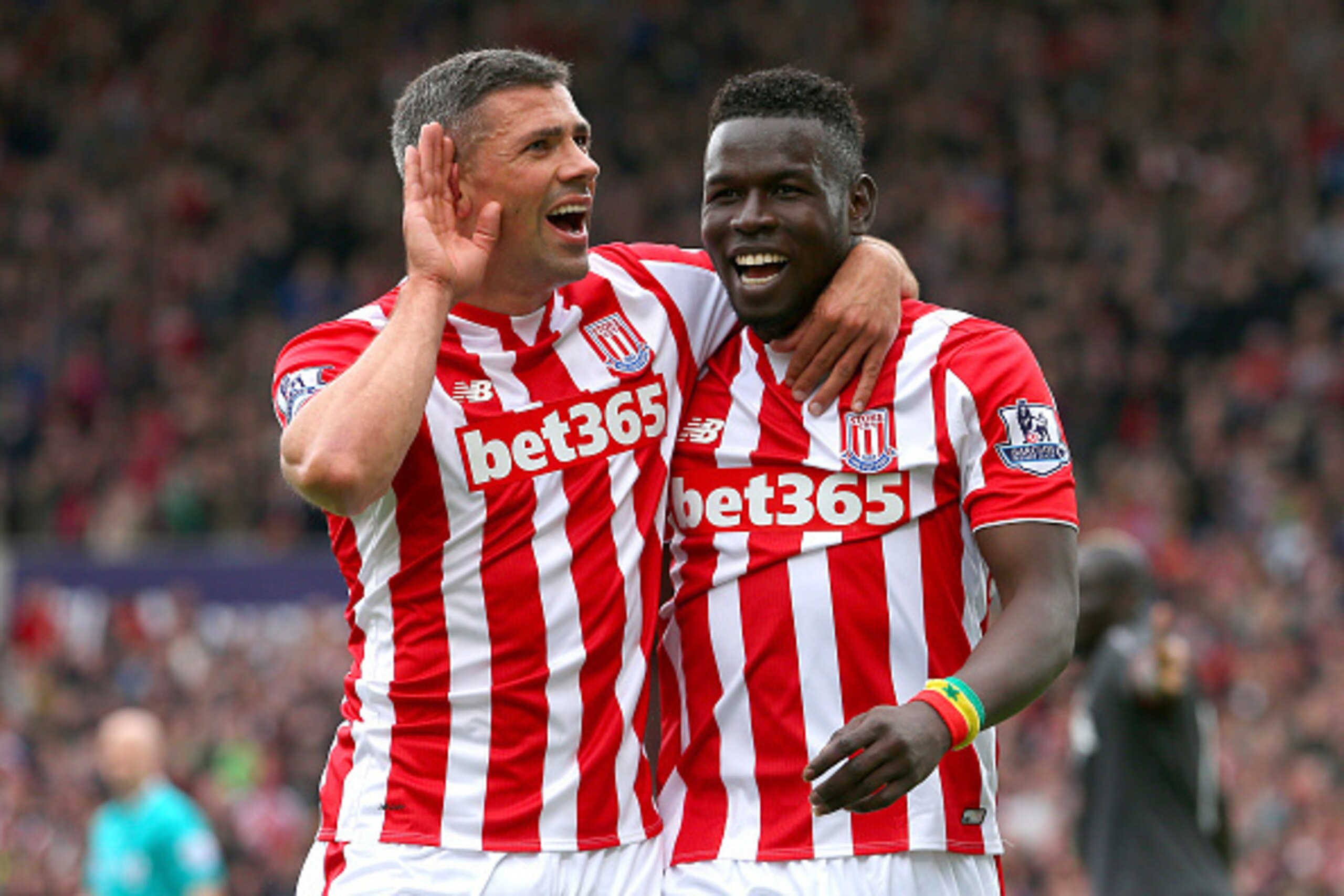 STOKE ON TRENT, ENGLAND - MAY 24: Mame Biram Diouf of Stoke City celebrates scoring a goal with his team mate Jonathan Walters during the Barclays Premier League match between Stoke City and Liverpool at Britannia Stadium on May 24, 2015 in Stoke on Trent