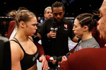 LAS VEGAS, NV - FEBRUARY 22:  Ronda Rousey (black shirt) and Sara McMann (grey shirt) face off before their women's bantamweight championship bout during UFC 170 inside the Mandalay Bay Events Center on February 22, 2014 in Las Vegas, Nevada. (Photo by Jo
