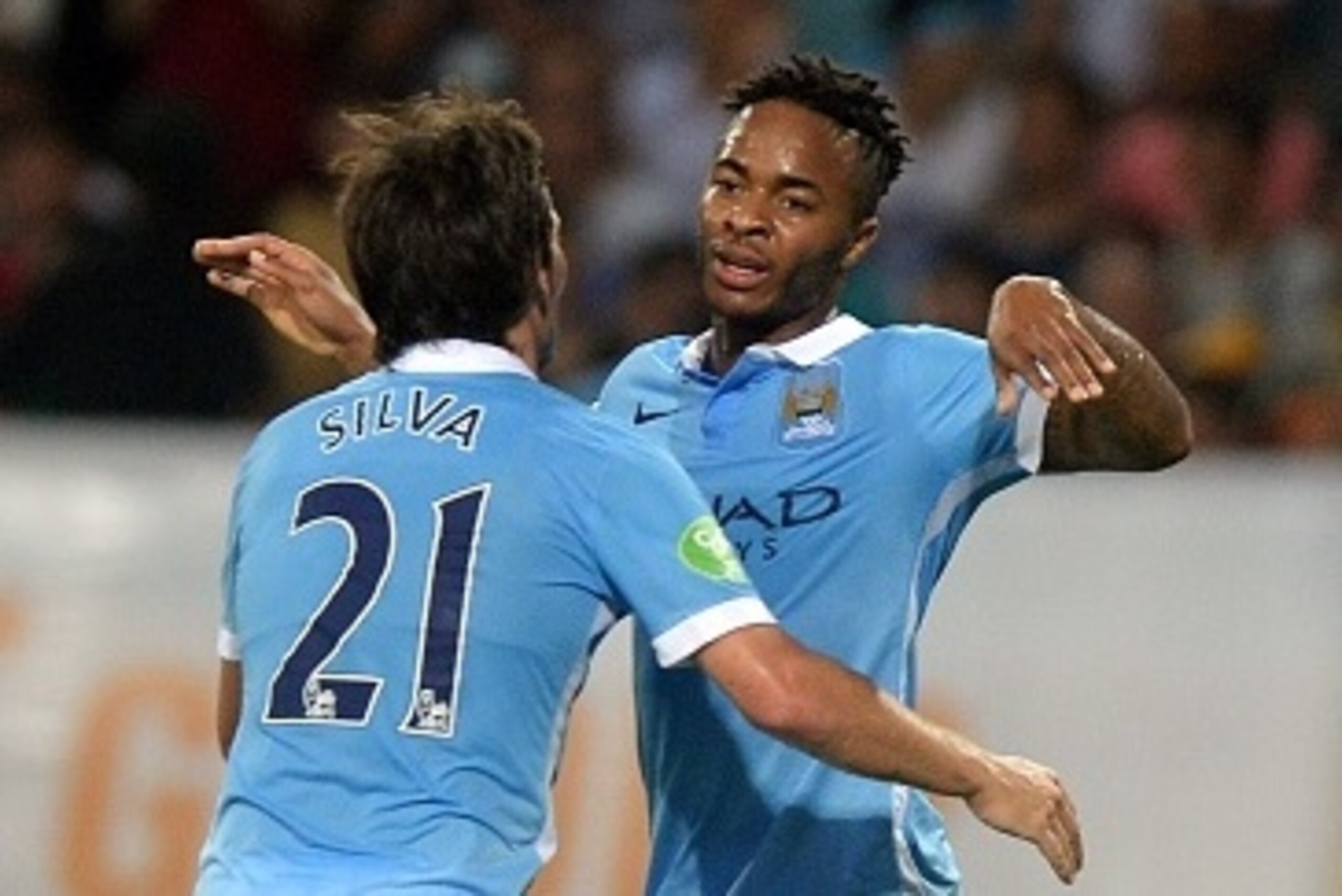 Manchester City's David Silva (L) and Raheem Sterling celebrate after Sterling scored a goal during a friendly football match against Vietnam's national team at My Dinh stadium in Hanoi on July 27, 2015. Manchester City won 8-1. AFP PHOTO / HOANG DINH NAM