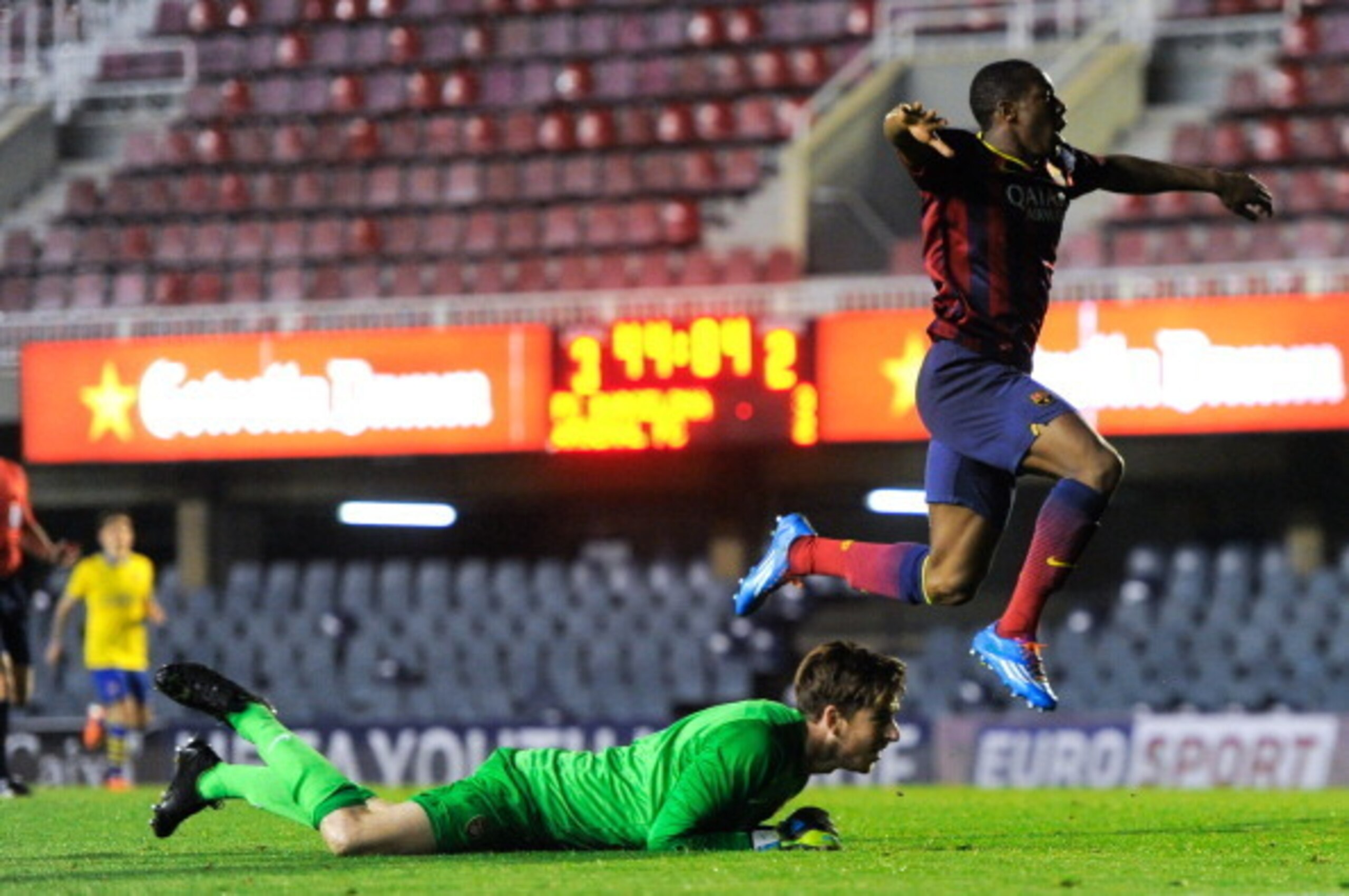 BARCELONA, SPAIN - MARCH 18:  Adama Traore of FC Barcelona celebrates past Josh Vickers of Arsenal after scoring his team's fourth goal during the UEFA Youth League Quarter FInal match between FC Barcelona U19 and Arsenal U19 at Mini Estadi on March 18, 2