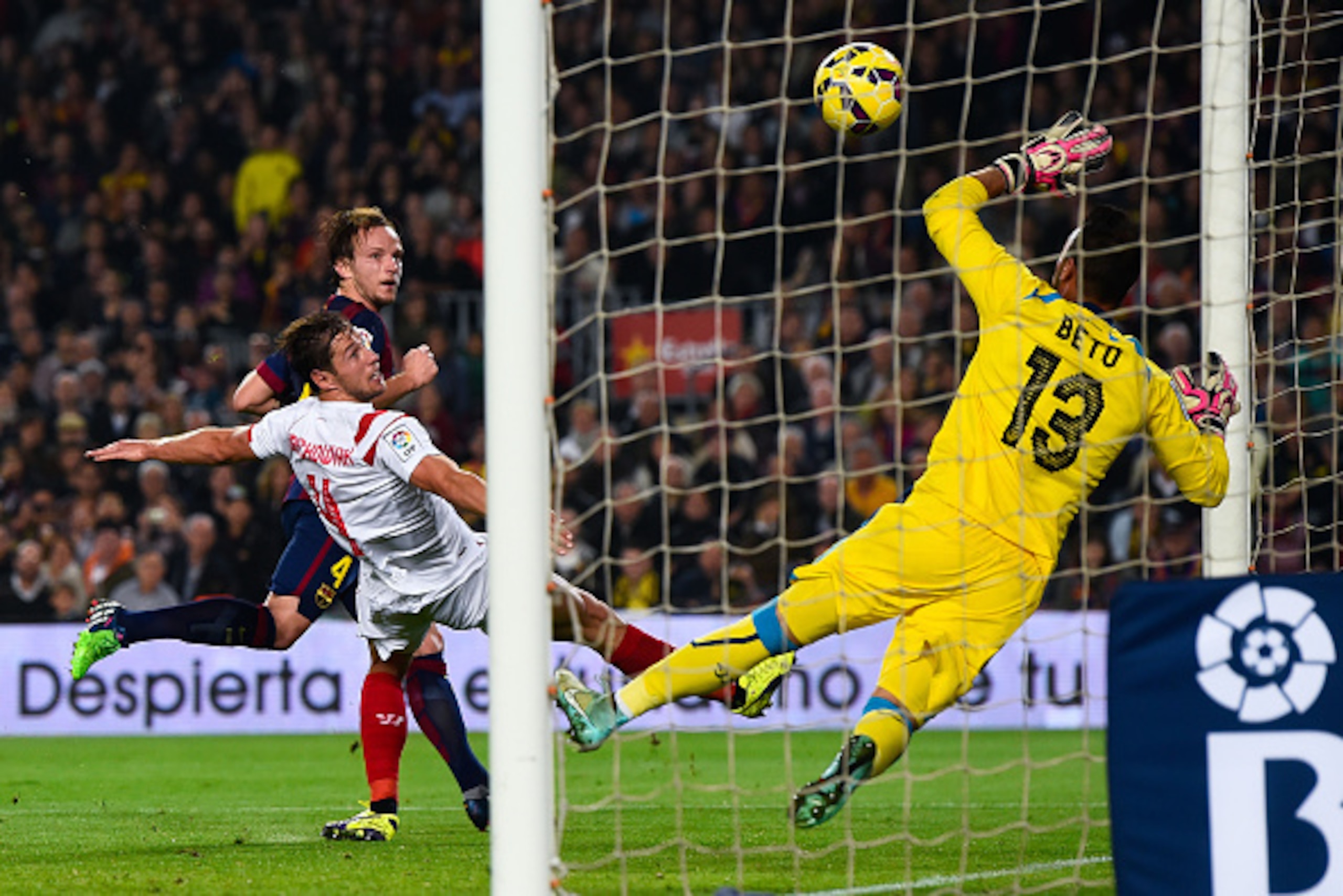 BARCELONA, SPAIN - NOVEMBER 22: Ivan Rakitic of FC Barcelona scores his team's third goal under a challenge by Grzegorz Krychowiak of Sevilla FC during the La Liga match between FC Barcelona and Sevilla FC at Camp Nou on November 22, 2014 in Barcelona, S BARCELONA, SPAIN - NOVEMBER 22: Ivan Rakitic of FC Barcelona scores his team's third goal under a challenge by Grzegorz Krychowiak of Sevilla FC during the La Liga match between FC Barcelona and Sevilla FC at Camp Nou on November 22, 2014 in Barcelona, S
