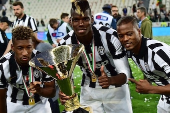 Juventus' midfielder from France Paul Pogba (C), Juventus' defender from France Patrice Evra (R) and Juventus' midfielder from France Kingsley Coman celebrate with the Italian League's trophy during a ceremony following the Italian Serie A football match 