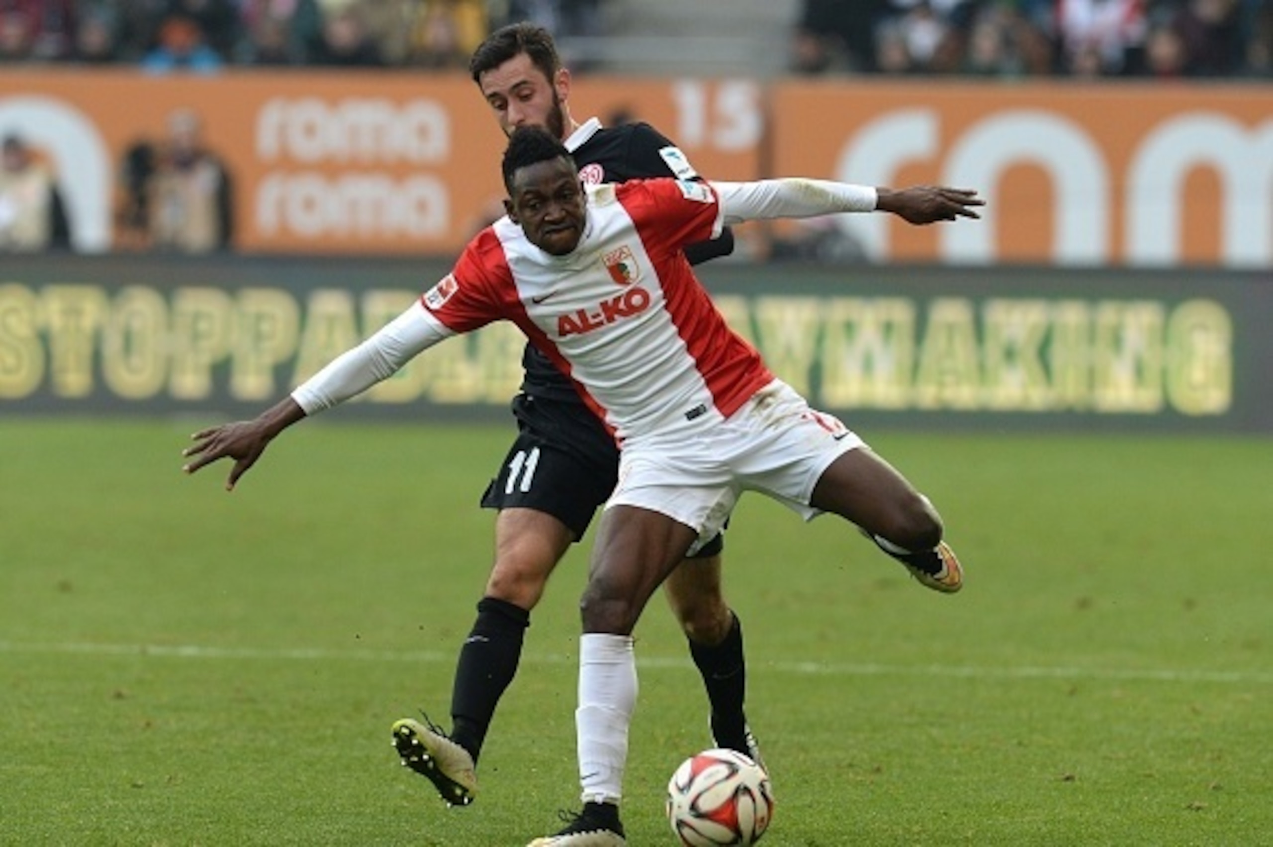 Augsburg's defender Abdul Rahman Baba (R) of Ghana and Mainz's midfielder Yunus Malli (L) vie for the ball during the German first division Bundesliga football match FC Augsburg v Mainz 05 in Augsburg, southern Germany, on March 14, 2015. AFP PHOTO /  CHR