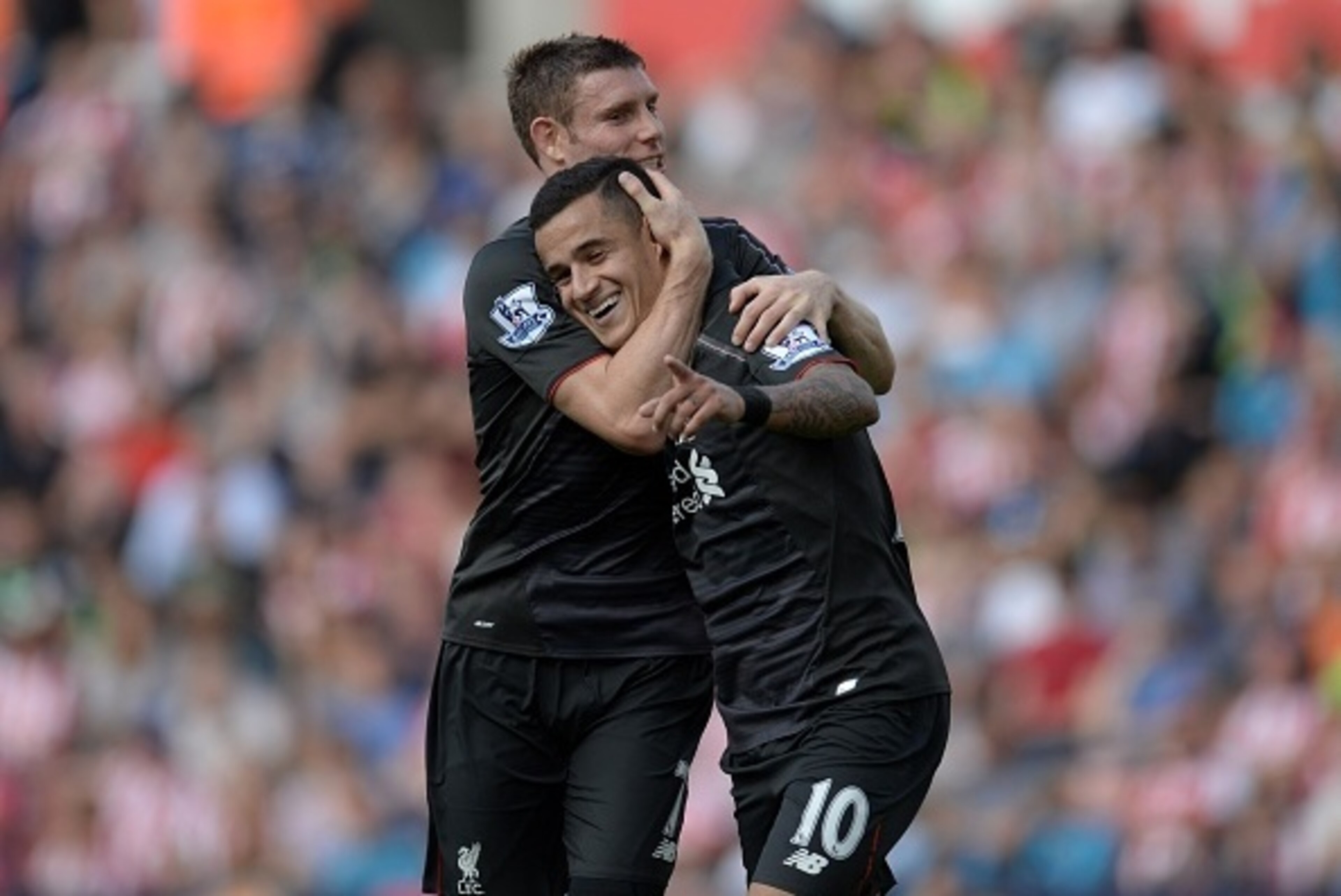 Liverpool's Brazilian midfielder Philippe Coutinho celebrates with Liverpool's English midfielder James Milner (L) after scoring the opening goal of the English Premier League football match between Stoke City and Liverpool at the Britannia Stadium in Sto