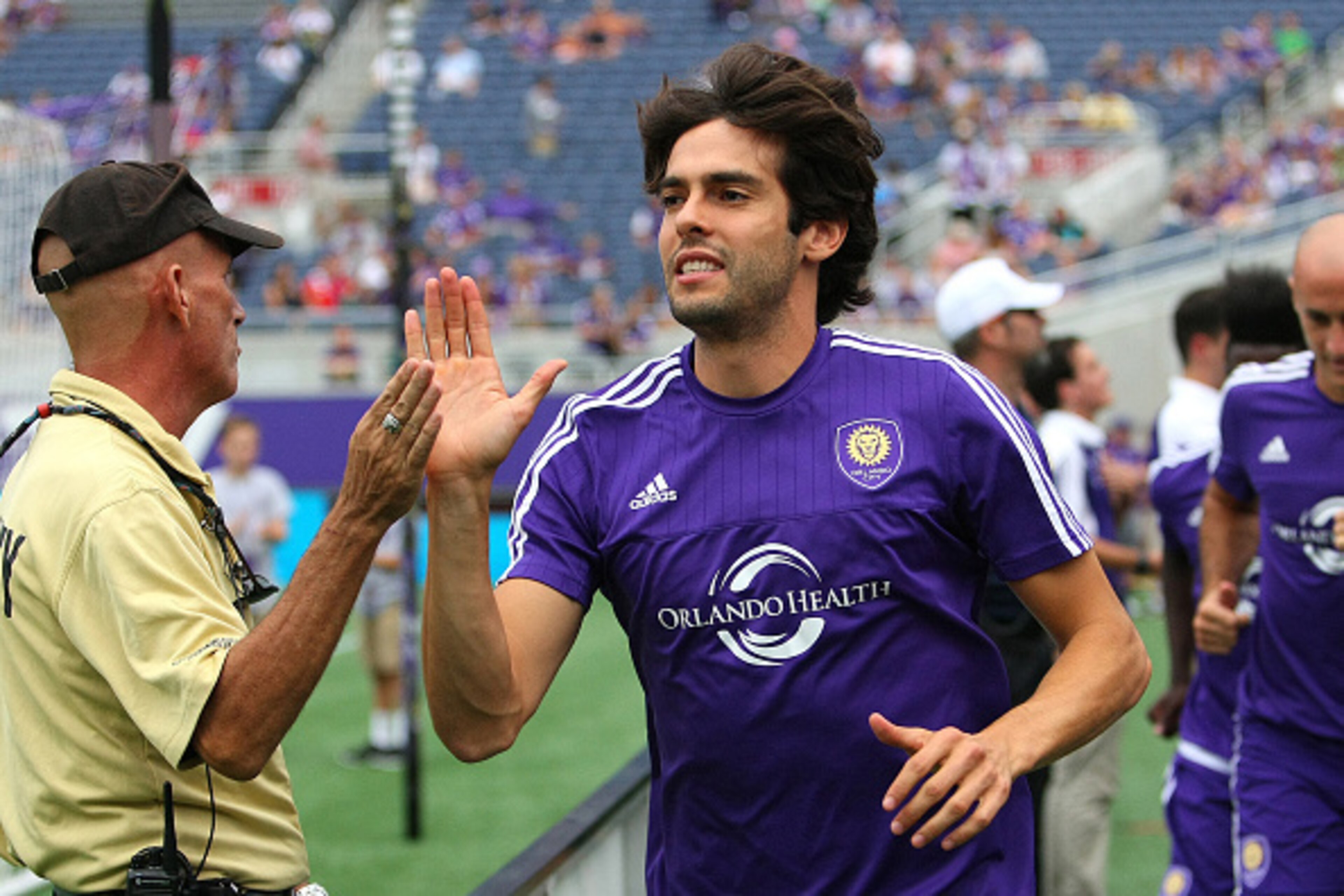ORLANDO, FL - AUGUST 01: Kaka #10 of Orlando City SC high fives a security member as he runs onto the pitch prior to a MLS soccer match between the Columbus Crew SC and the Orlando City SC at the Orlando Citrus Bowl on August 1, 2015 in Orlando, Florida. 