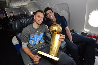 OAKLAND, CA - JUNE 17:  Stephen Curry #30 and Bob Myers of the Golden State Warriors holds the NBA trophy on the plane as the team travels home from Cleveland after winning the 2015 NBA Finals on June 17, 2015 in Oakland, California. NOTE TO USER: User ex