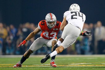 ARLINGTON, TX - JANUARY 12:  Linebacker Darron Lee #43 of the Ohio State Buckeyes looks to tackle running back Thomas Tyner #24 of the Oregon Ducks during the College Football Playoff National Championship Game at AT&T Stadium on January 12, 2015 in Arlin