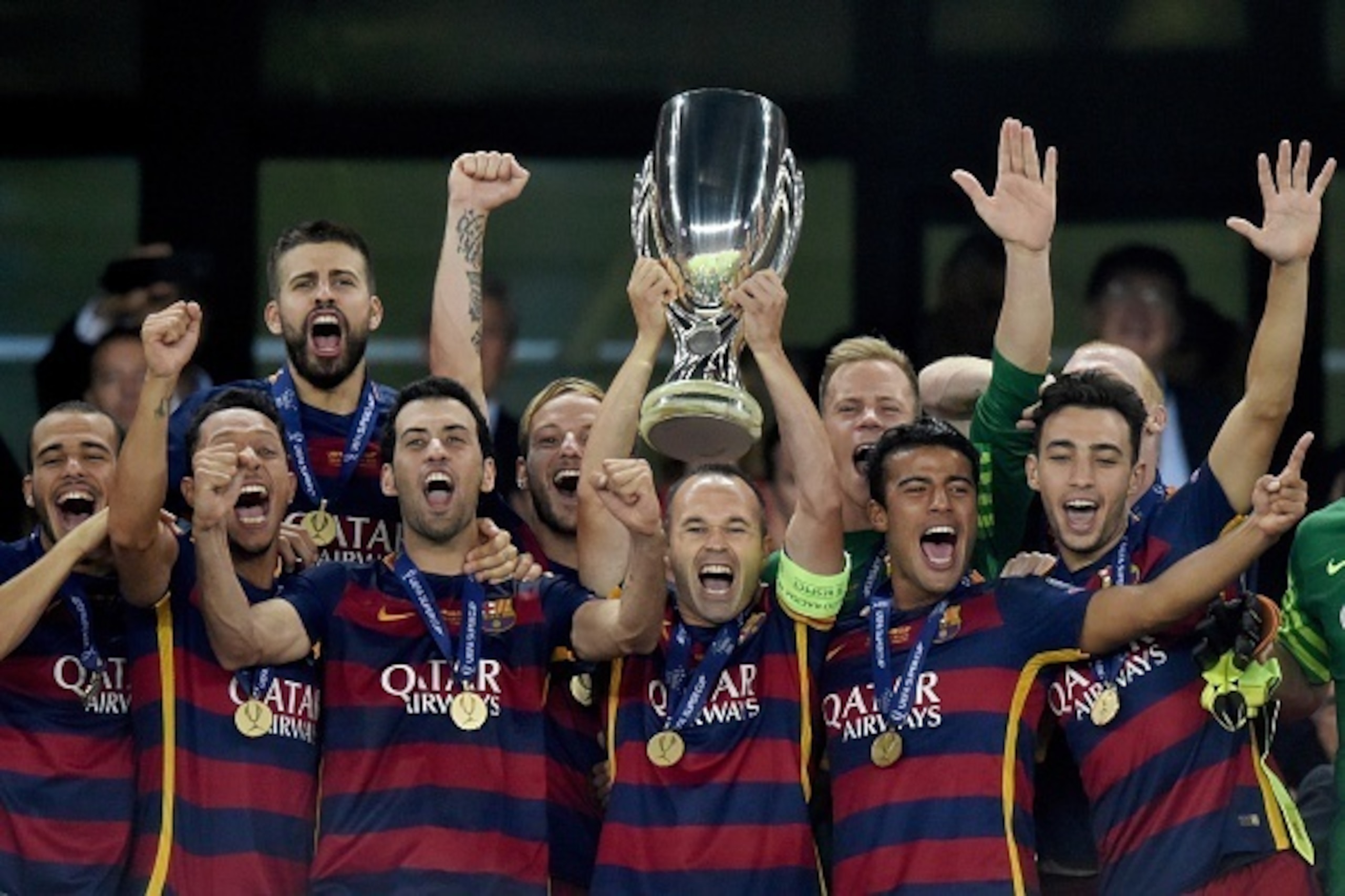 FC Barcelona's team celebrates with the trophy after winning the UEFA Super Cup final football match between FC Barcelona and Sevilla FC on August 11, 2015 at the Boris Paichadze Dinamo Arena in Tbilisi. AFP PHOTO / KIRILL KUDRYAVTSEV        (Photo credit