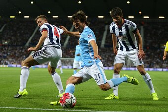 WEST BROMWICH, ENGLAND - AUGUST 10: David Silva of Manchester City crosses the ball past James Chester and Claudio Yacob of West Bromwich Albion, from which Vincent Kompany of Manchester City scores to make it 0-3 during the Barclays Premier League match 