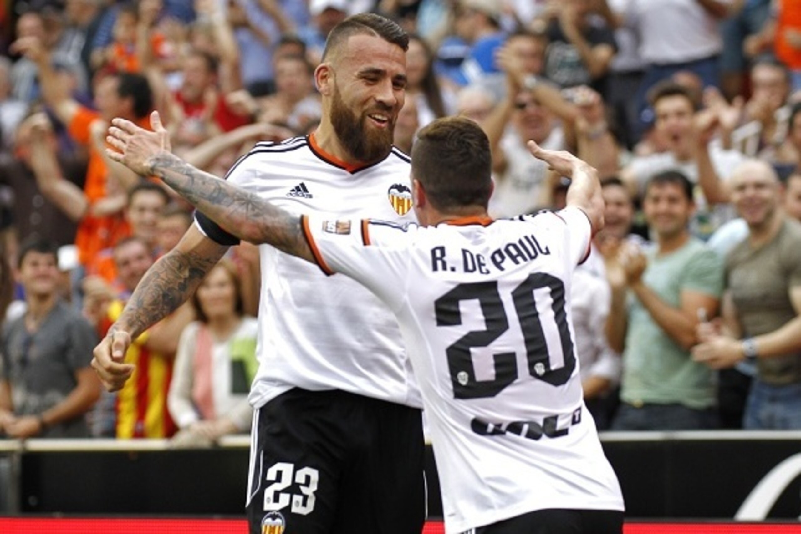 Valencia's Argentinian defender Nicolas Otamendi (L) celebrates with Valencia's Argentinian midfielder Rodrigo de Paul after scoring during the Spanish league football match Valencia CF vs SD Eibar at the Mestalla stadium in Valencia on May 3, 2015.   AFP