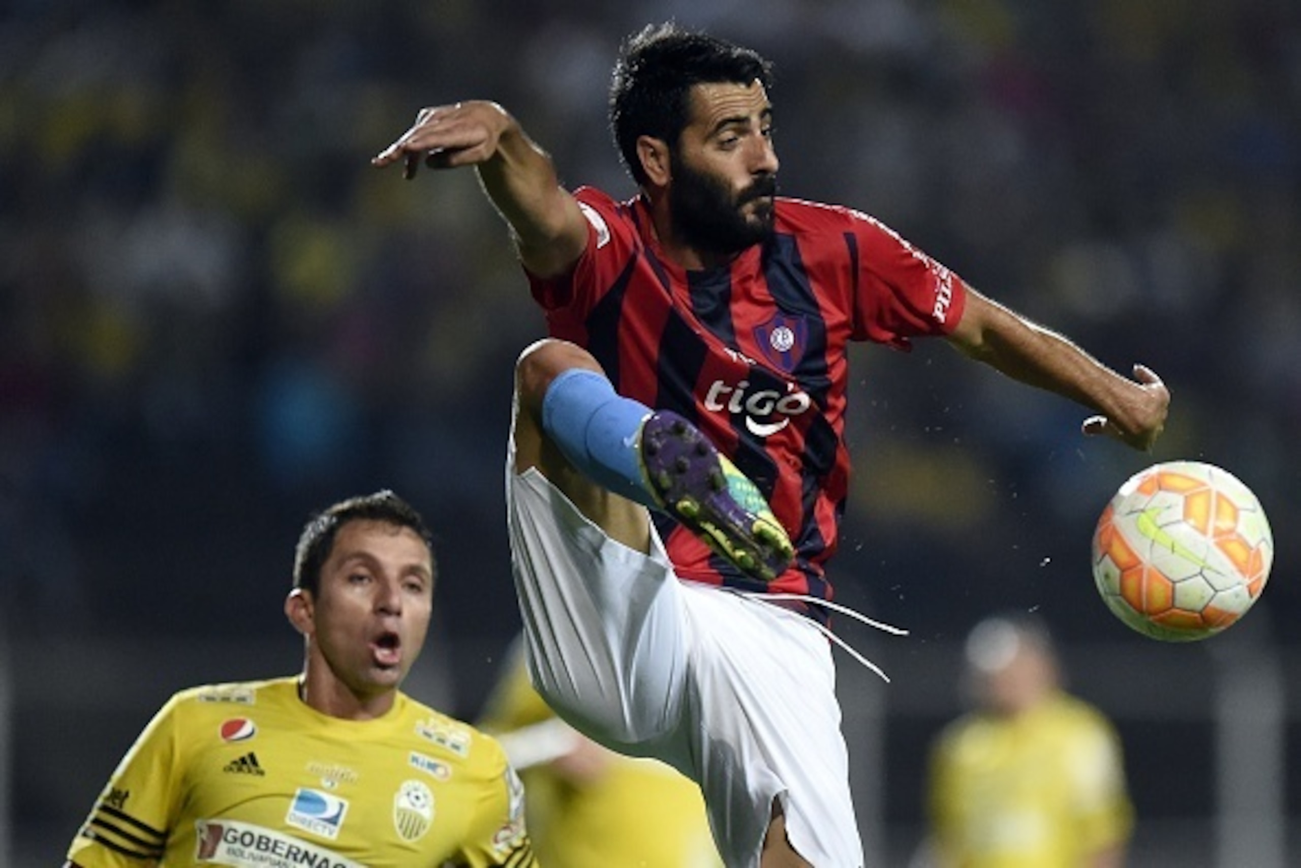Venezuelan Deportivo Tachira Gerzon Chacon (L) player  vies for the ball with Daniel Guiza (R) of Cerro Porteno during their Libertadores Cup football match at the in Pueblo Nuevo stadium in San Cristobal on February  4, 2015. AFP PHOTO / JUAN BARRETO    