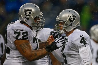SEATTLE, WA - NOVEMBER 02:  Quarterback Derek Carr #4 of the Oakland Raiders is checked on by tackle Donald Penn #72 after being sacked against the Seattle Seahawks at CenturyLink Field on November 2, 2014 in Seattle, Washington. The Seahawks defeated the