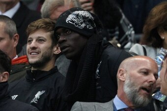 Liverpool's Italian striker Mario Balotelli (C) who signed for the club earlier in the day, is seen in the crowd with Liverpool's English midfielder Adam Lallana (L) during the English Premier League football match between Manchester City and Liverpool at