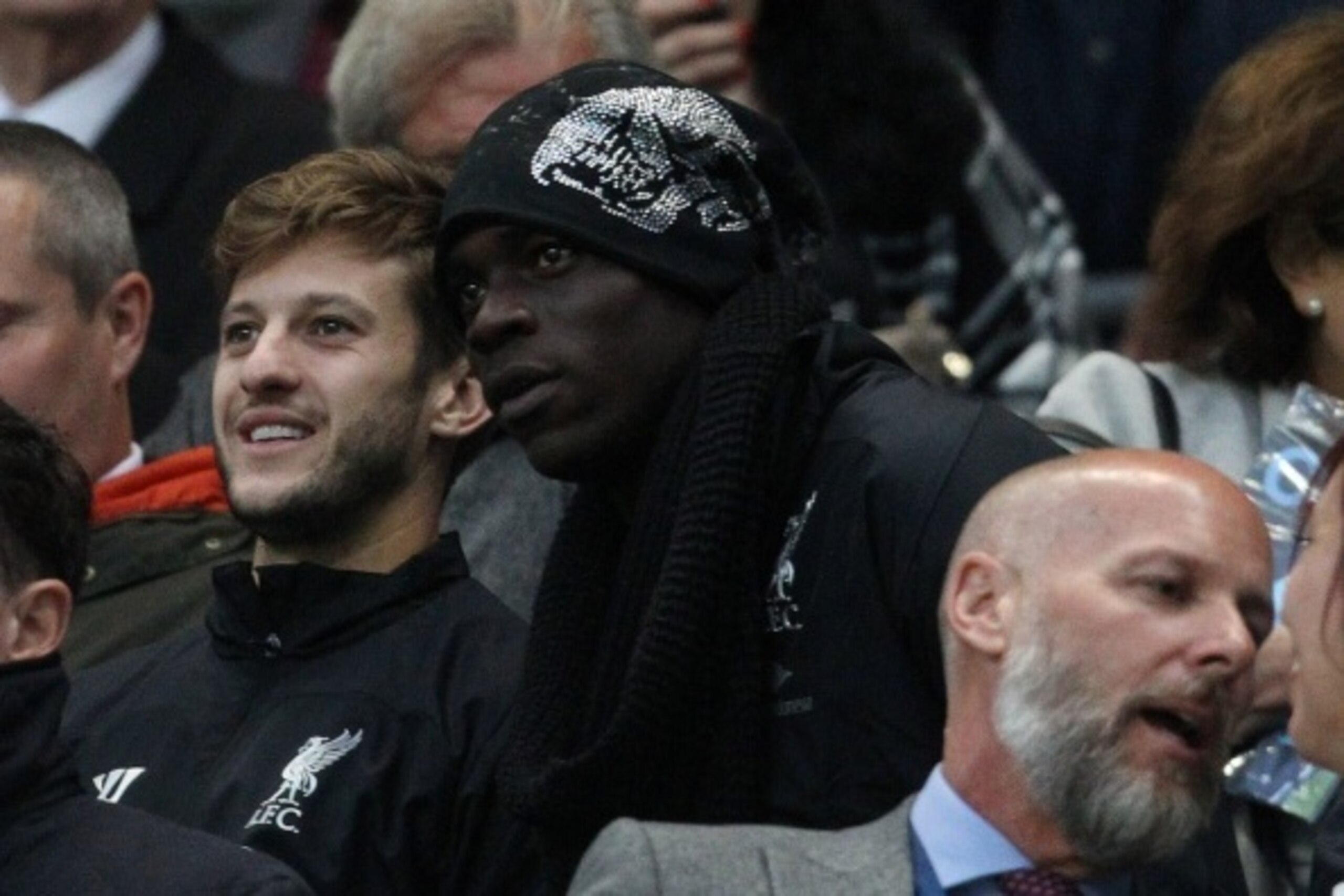 Liverpool's Italian striker Mario Balotelli (C) who signed for the club earlier in the day, is seen in the crowd with Liverpool's English midfielder Adam Lallana (L) during the English Premier League football match between Manchester City and Liverpool at