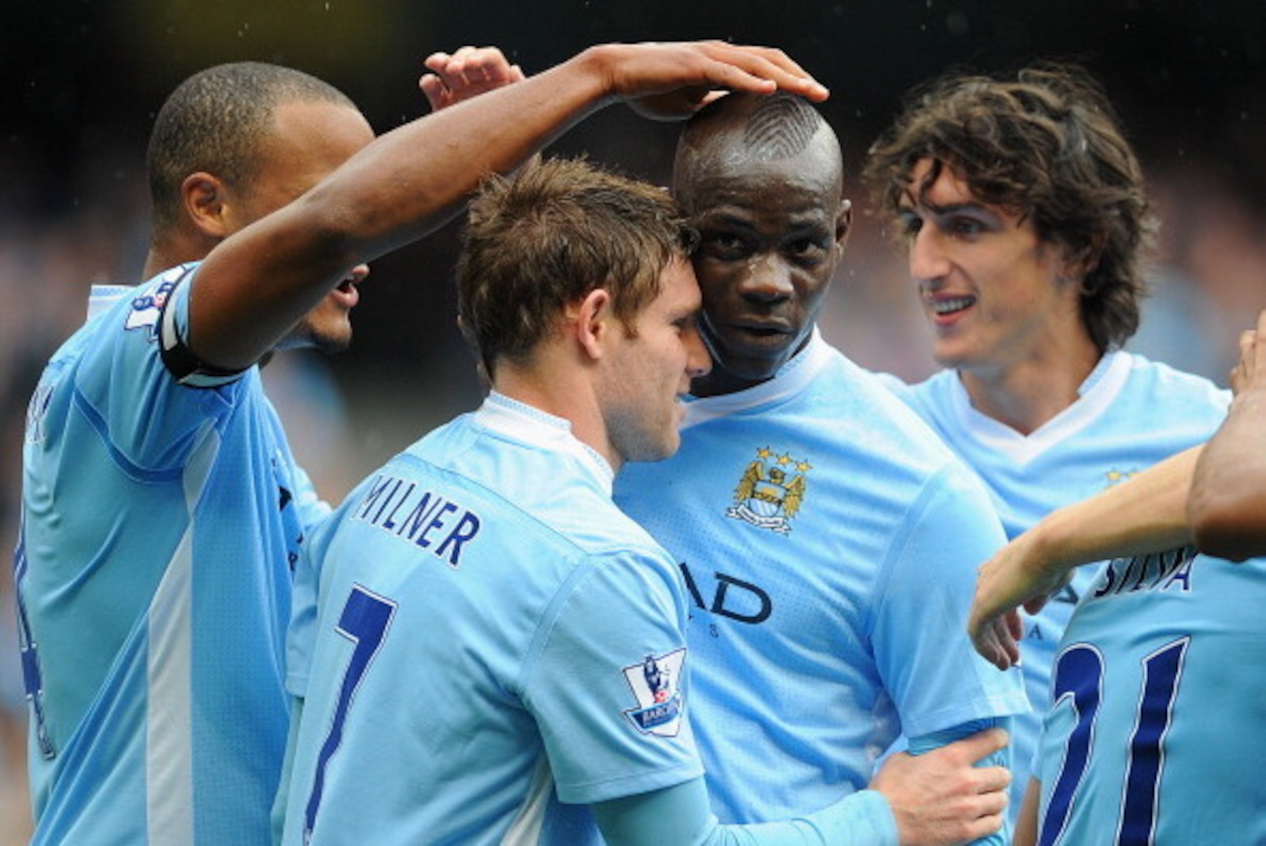 MANCHESTER, ENGLAND - SEPTEMBER 24:  James Milner of Manchester City celebrates scoring to make it 2-0 with team mate Mario Balotelli during the Barclays Premier League match between Manchester City and Everton at the Etihad Stadium on September 24, 2011 
