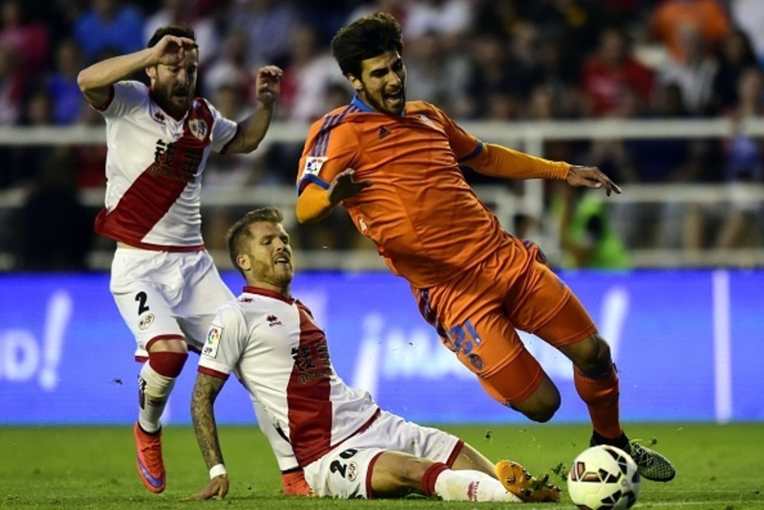 Valencia's Portuguese midfielder Andre Gomes (R) vies with Rayo Vallecano's defender Jorge Morcillo (C) and Rayo Vallecano's defender Tito during the Spanish league football match Rayo Vallecano de Madrid vs Valencia CF at Vallecas stadium in Madrid on Ap