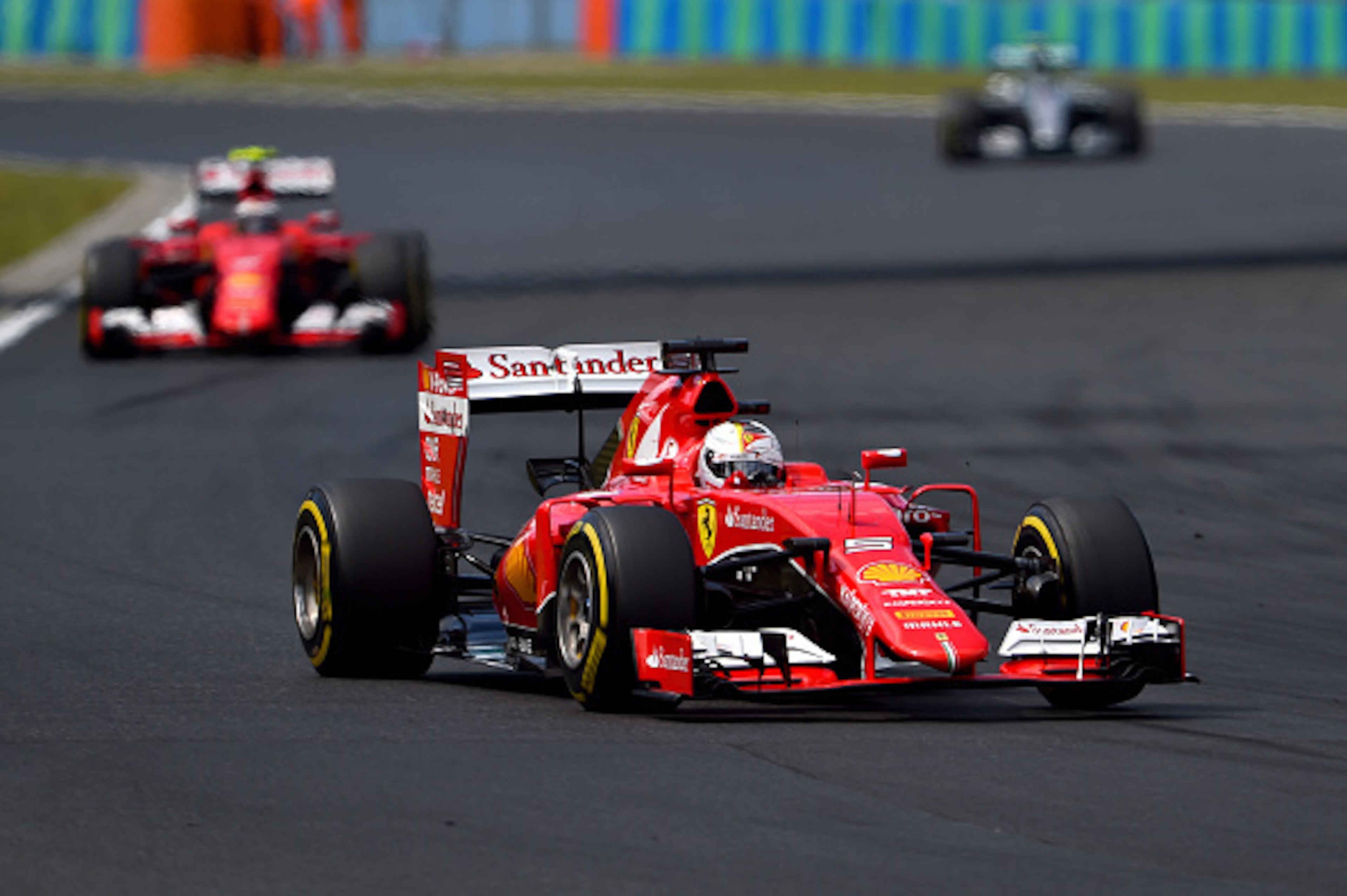 BUDAPEST, HUNGARY - JULY 26:  Sebastian Vettel of Germany and Ferrari drives ahead of Kimi Raikkonen of Finland and Ferrari and Nico Rosberg of Germany and Mercedes GP during the Formula One Grand Prix of Hungary at Hungaroring on July 26, 2015 in Budapes