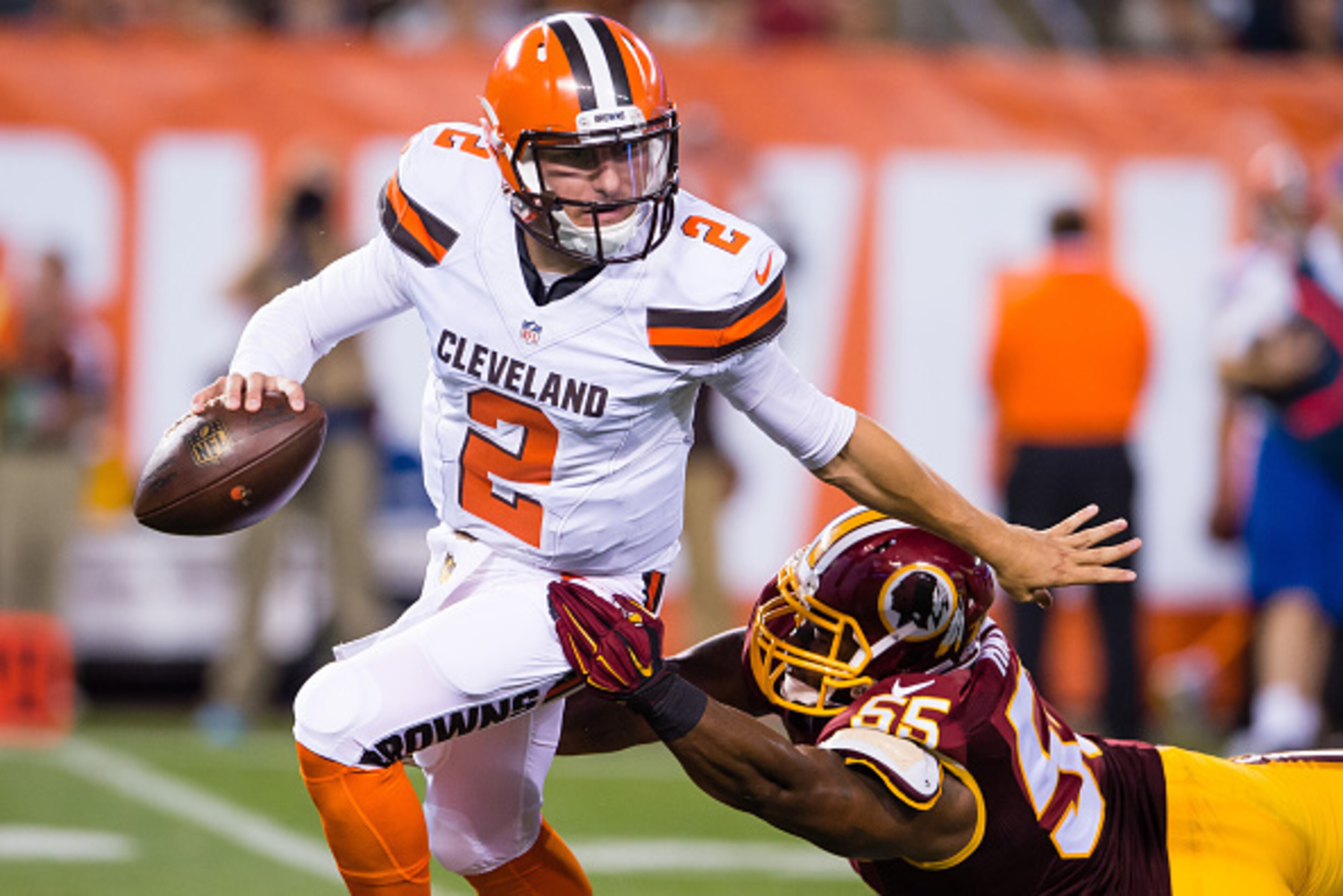 CLEVELAND, OH - AUGUST 13: Quarterback Johnny Manziel #2 of the Cleveland Browns brushes off a tackle by outside linebacker Adam Hayward #55 of the Washington Redskins during the first half at FirstEnergy Stadium on August 13, 2015 in Cleveland, Ohio. (Ph