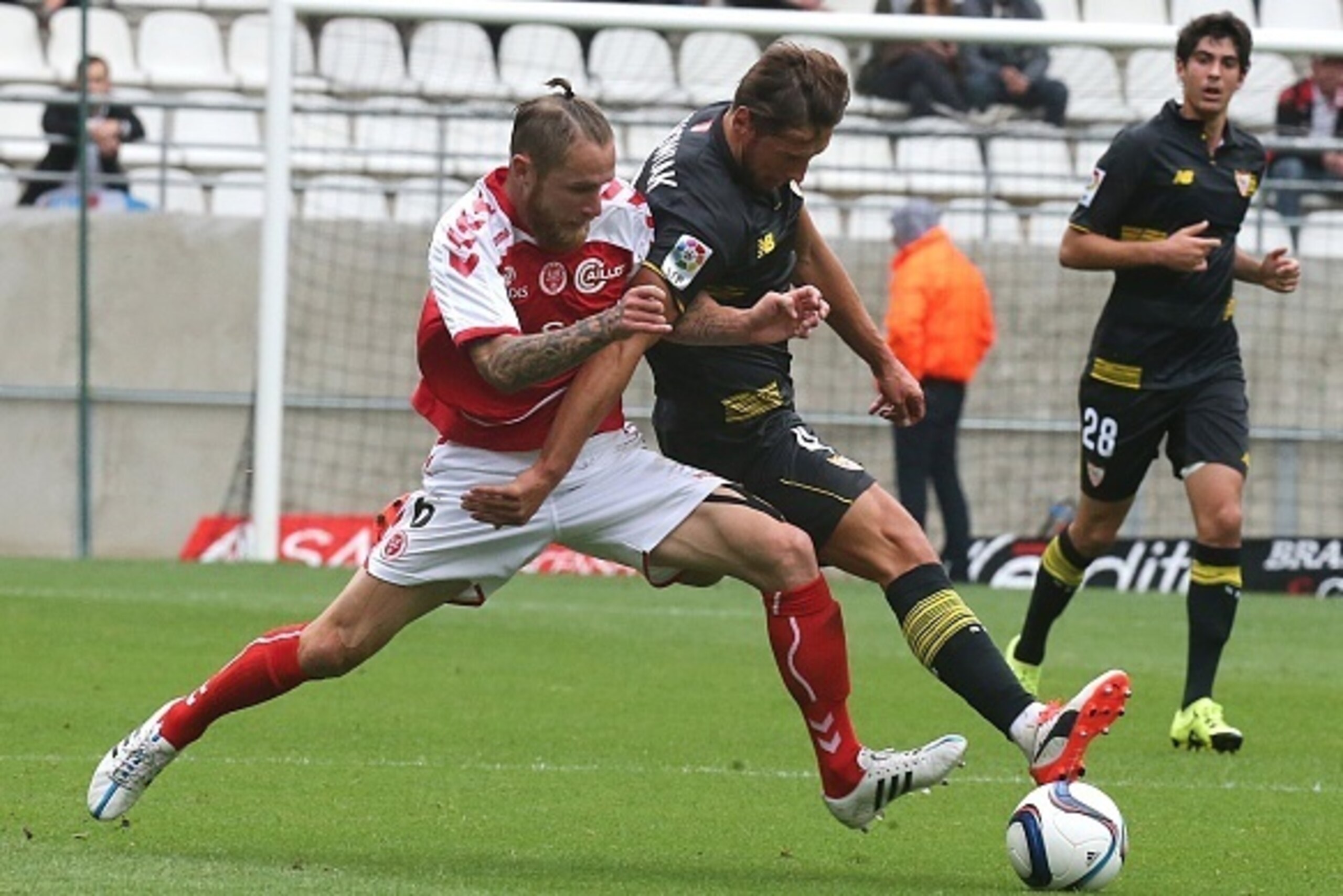 Reims' French midfielder Antoine Devaux (L) vies with Seville's Polish defender Grzegorz Krychowiak (R) during the friendly football match between Reims and Seville on July 26, 2015 at the Auguste Delaune Stadium in Reims. AFP PHOTO / FRANCOIS NASCIMBENI 