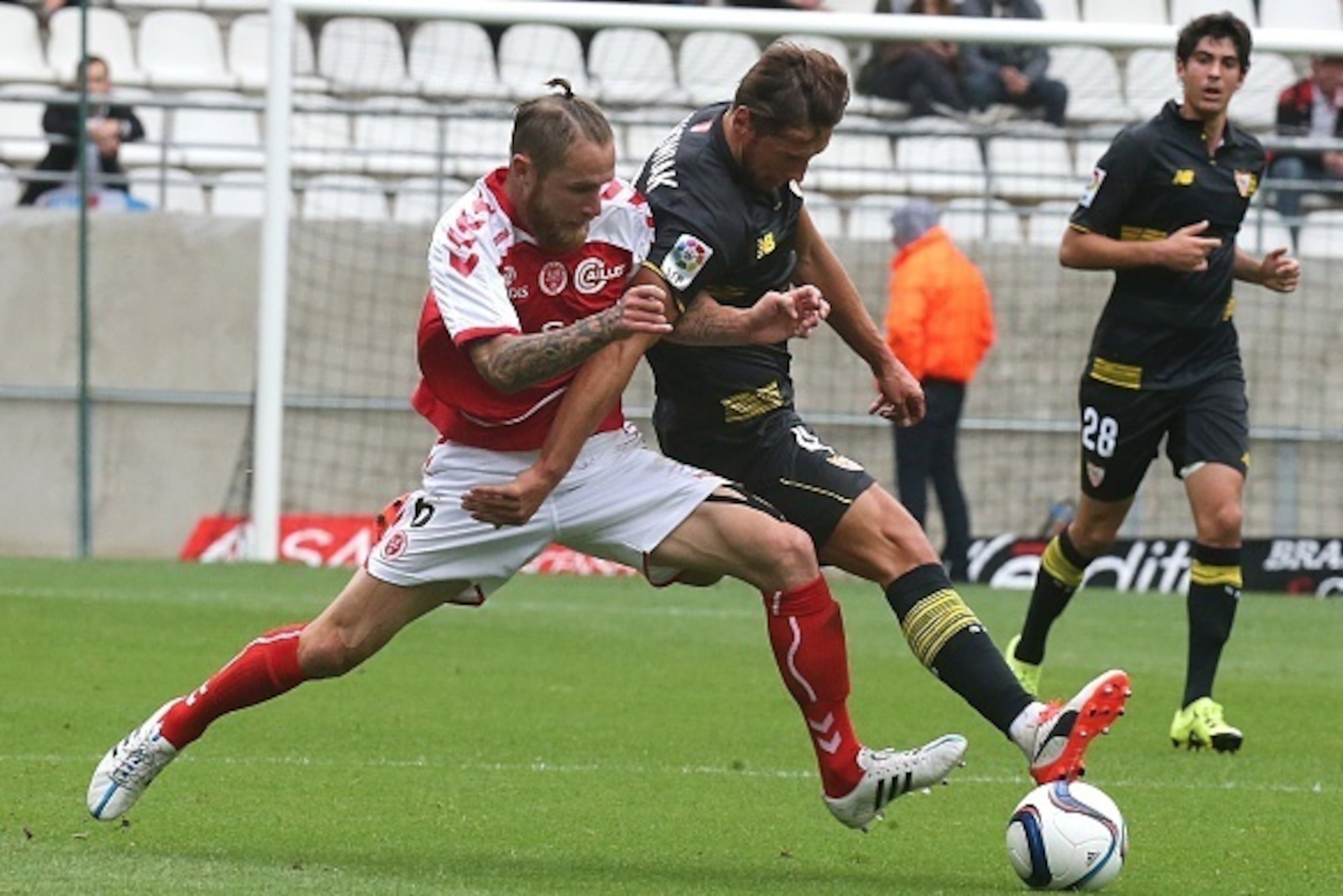 Reims' French midfielder Antoine Devaux (L) vies with Seville's Polish defender Grzegorz Krychowiak (R) during the friendly football match between Reims and Seville on July 26, 2015 at the Auguste Delaune Stadium in Reims. AFP PHOTO / FRANCOIS NASCIMBENI 