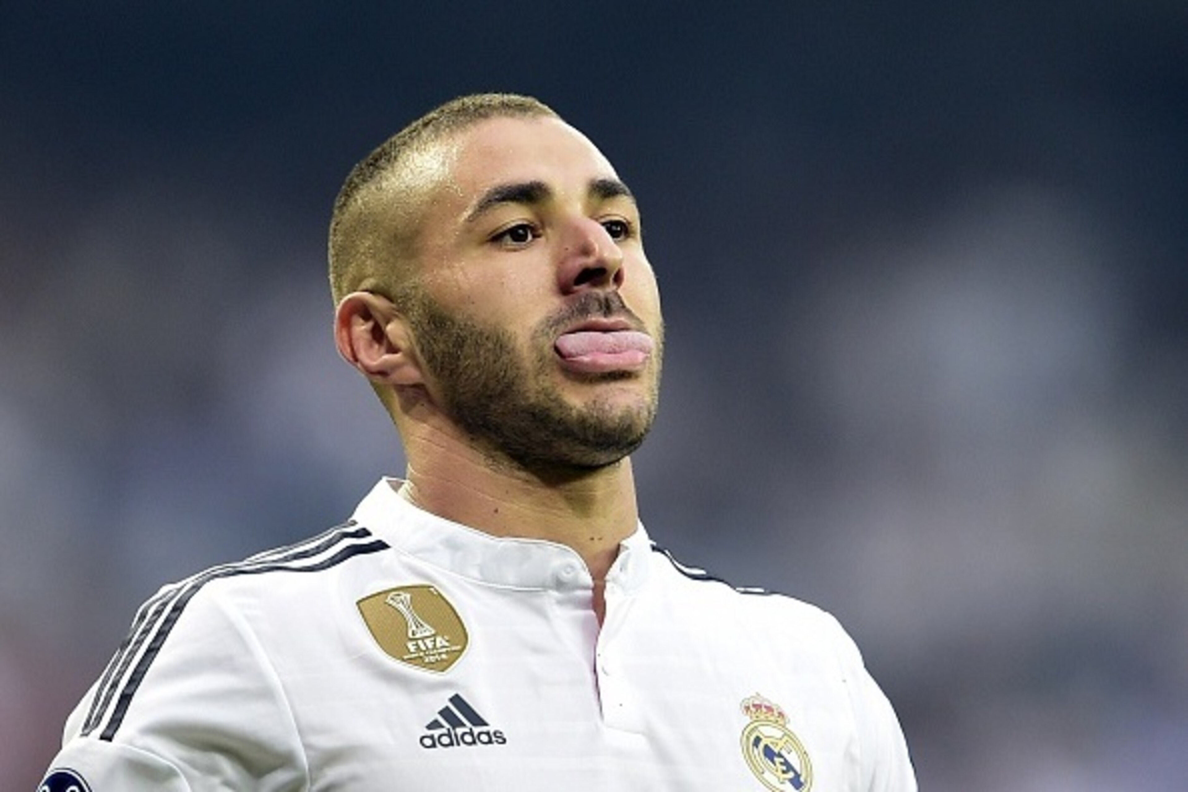 Real Madrid's French forward Karim Benzema sticks out his tongue during the UEFA Champions League semi-final second leg football match Real Madrid FC vs Juventus at the Santiago Bernabeu stadium in Madrid on May 13, 2015.   AFP PHOTO/ GERARD JULIEN       