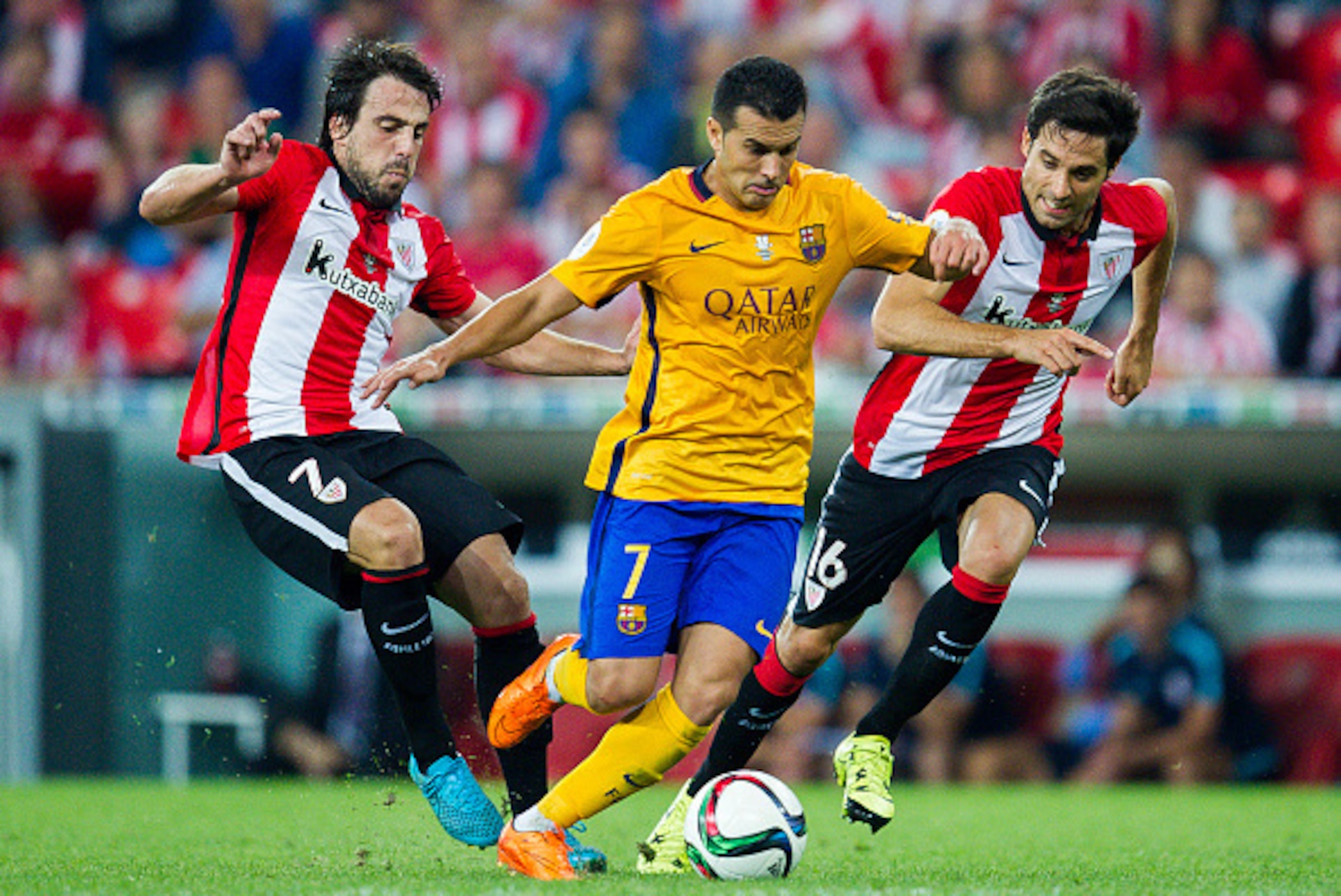 BILBAO, SPAIN - AUGUST 14: Pedro Rodriguez of FC Barcelona (C) duels for the ball with Benat Etxebarria (L) of Athletic Club during the Super Cup first leg match between of Athletic Club and FC Barcelona at San Mames Stadium on August 14, 2015 in Bilbao, 