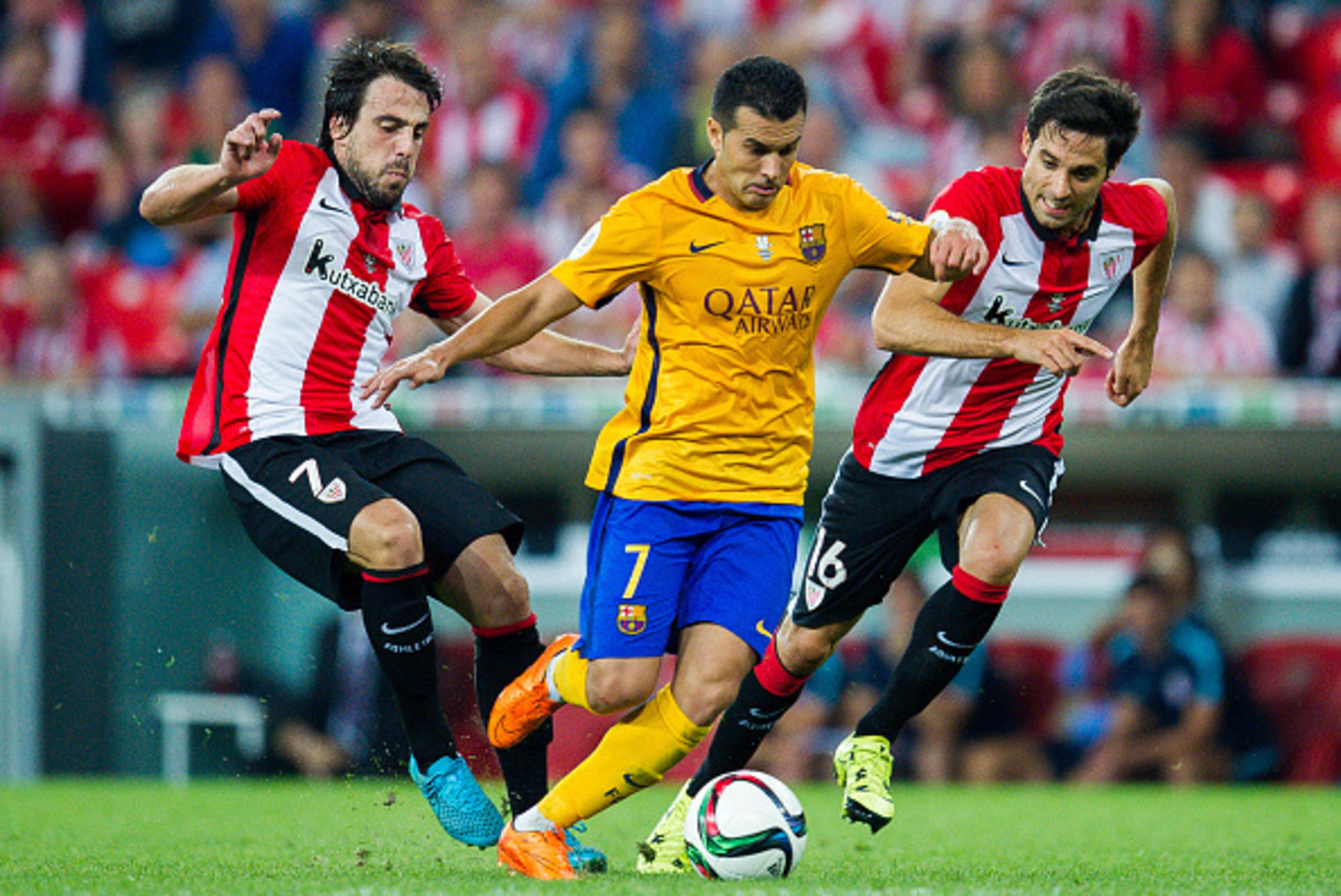 BILBAO, SPAIN - AUGUST 14: Pedro Rodriguez of FC Barcelona (C) duels for the ball with Benat Etxebarria (L) of Athletic Club during the Super Cup first leg match between of Athletic Club and FC Barcelona at San Mames Stadium on August 14, 2015 in Bilbao, 