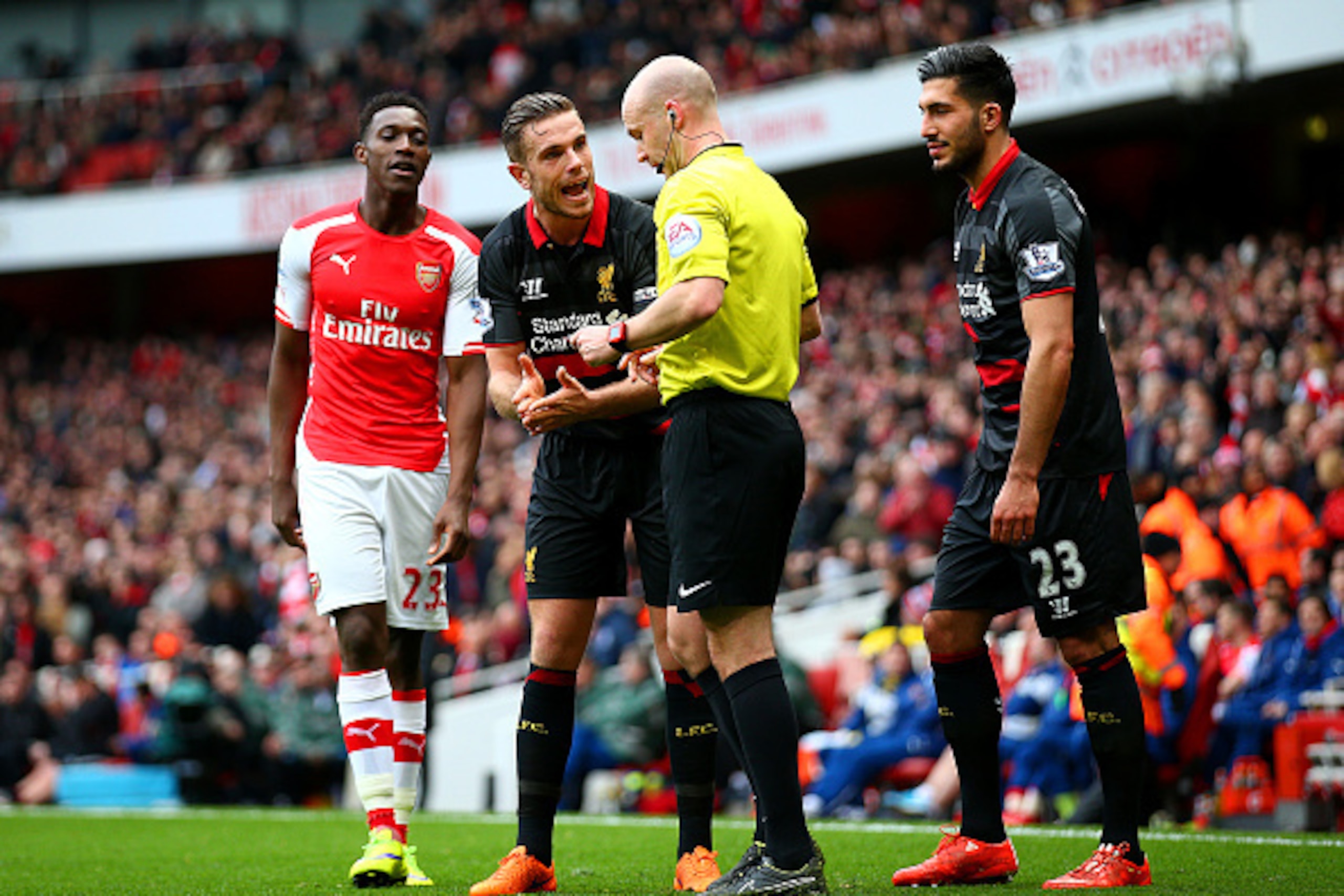 LONDON, ENGLAND - APRIL 04:  Jordan Henderson of Liverpool argues with referee Anthony Taylor as Emre Can of Liverpool is sent off for a challenge on Danny Welbeck of Arsenal during the Barclays Premier League match between Arsenal and Liverpool at Emirat