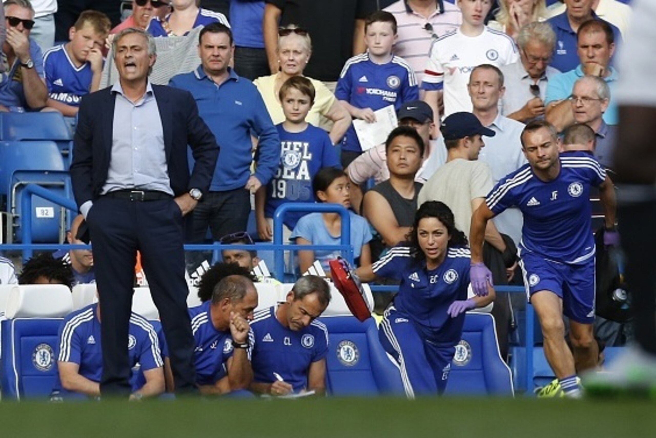 Chelsea doctor (2R) Eva Carneiro and head physio Jon Fearn (R) leave the bench to treat Chelsea's Belgian midfielder Eden Hazard late in the game as Chelsea's Portuguese manager Jose Mourinho (L) gestures during the English Premier League football match b