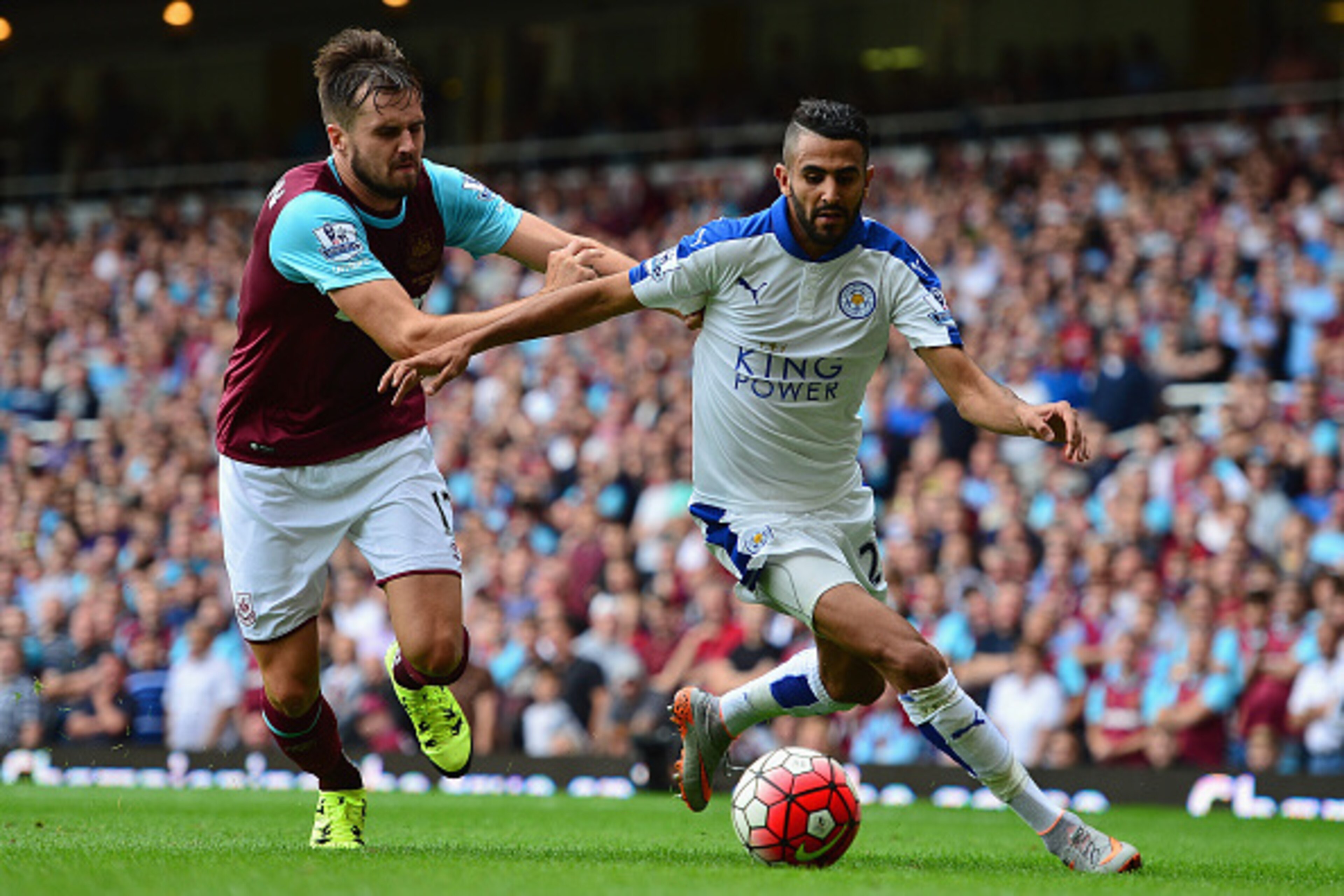 LONDON, ENGLAND - AUGUST 15: Riyad Mahrez of Leicester City and Carl Jenkinson of West Ham United compete for the ball during the Barclays Premier League match between West Ham United and Leicester City at the Boleyn Ground on August 15, 2015 in London, U