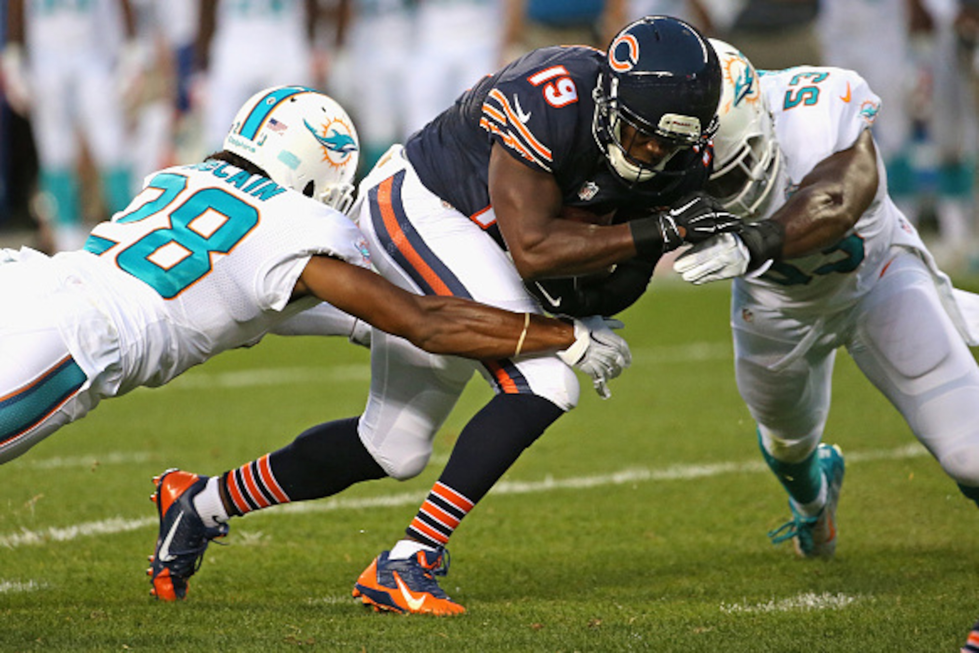 CHICAGO, IL - AUGUST 13: Eddie Royal #19 of the Chicago Bears is hit after a catch by Jamar Taylor #22 and Jelani Jenkins #53 of the Miami Dolphins
during a preseason game at Soldier Field on August 13, 2015 in Chicago, Illinois. (Photo by Jonathan Daniel