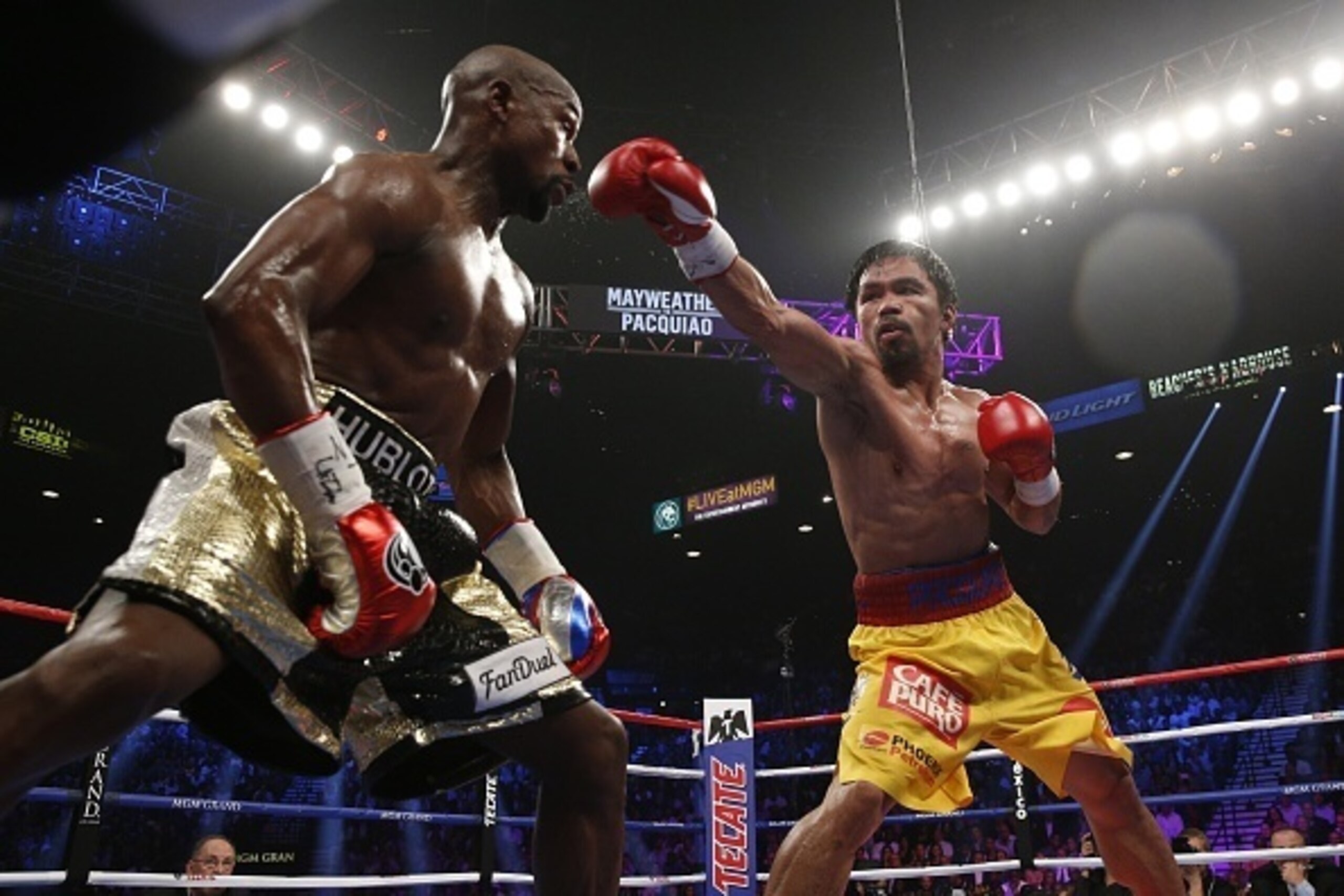 Floyd Mayweather Jr. exchange punches with Manny Pacquiao during their welterweight unification championship bout, May 2, 2015 at MGM Grand Garden Arena in Las Vegas, Nevada.  Mayweather defeated Pacquiao by unanimous decision.  AFP PHOTO / JOHN GURZINKSI