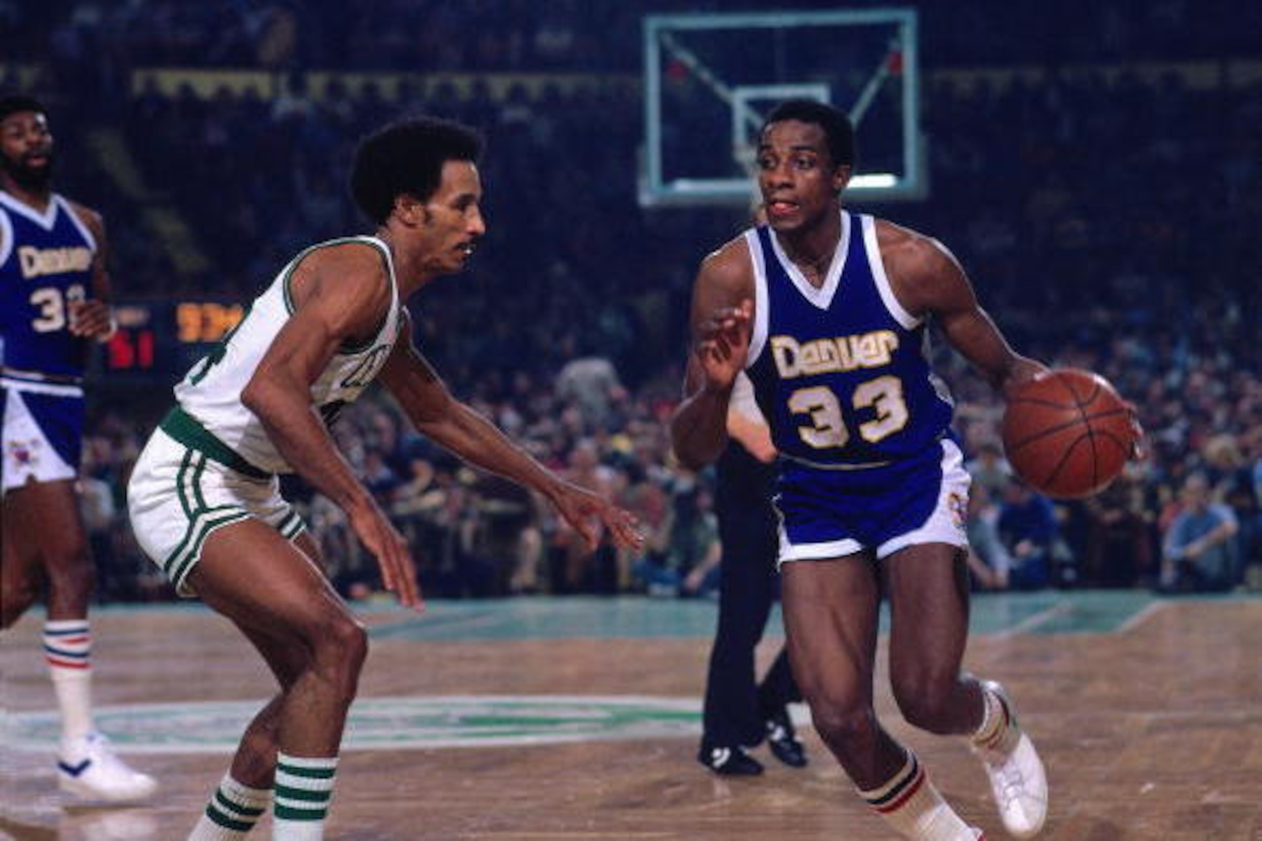BOSTON - 1975:  David Thompson #33 of the Denver Nuggets moves the ball up court against Dave Bing #44 of the Boston Celtics during a game played in 1975 at the Boston Garden in Boston, Massachusetts. NOTE TO USER: User expressly acknowledges and agrees t