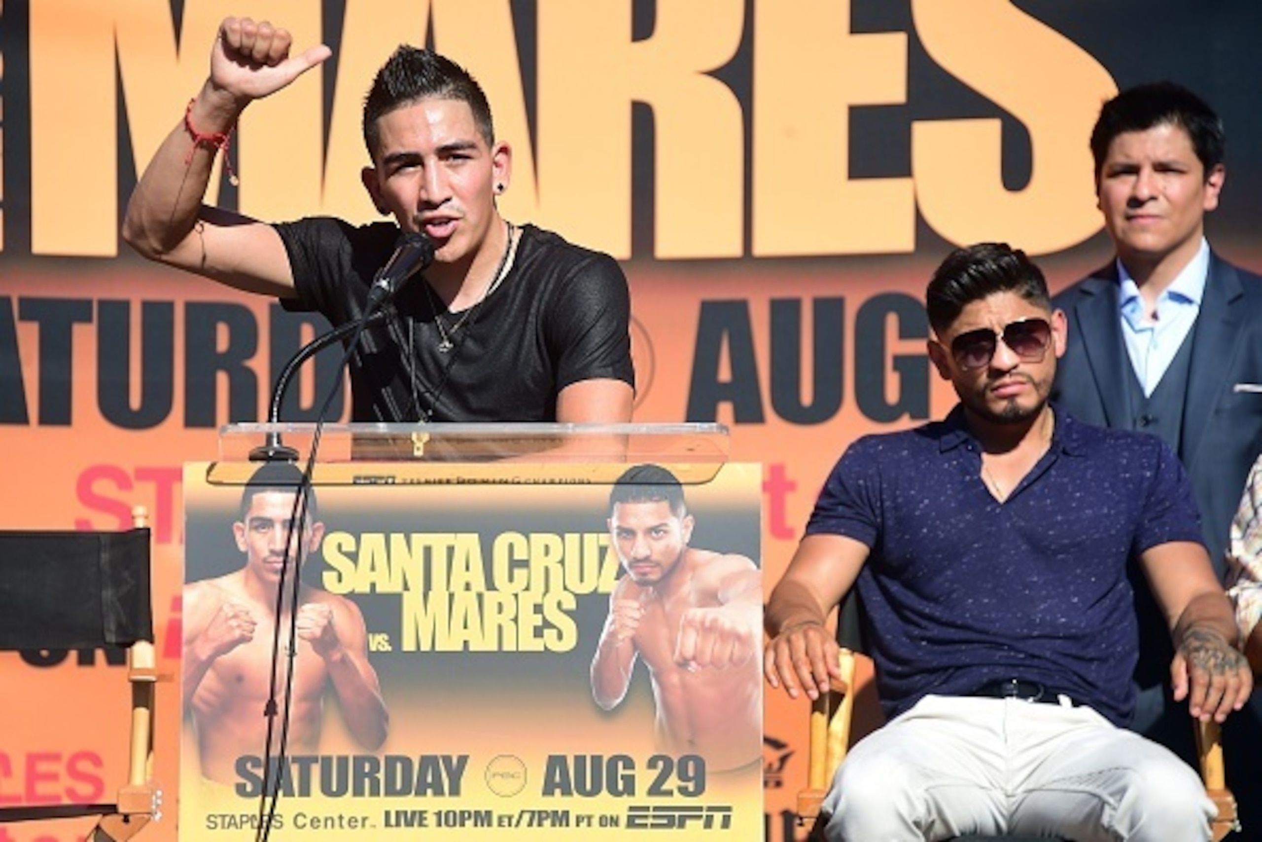 Undefeated two-Division World Champion Leo 'El Terremoto' Santa Cruz (L) speaks as former three-division world champion Abner Mares (R)  looks on at a press conference in Los Angeles on July 14, 2015, to announce their 12-round featherweight fight taking 