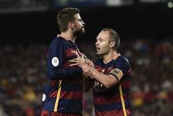 Barcelona's midfielder Andres Iniesta (R) tries to calm teammate Barcelona's defender Gerard Pique after being sent off during the Spanish Supercup second-leg football match FC Barcelona vs Athletic club Bilbao at the Camp Nou stadium in Barcelona on Augu