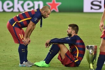 Barcelona's Spanish defender Gerard Pique and Barcelona's Argentinian defender Javier Mascherano (L) react after winning the UEFA Super Cup final football match between FC Barcelona and Sevilla FC on August 11, 2015 at the Boris Paichadze Dinamo Arena in 