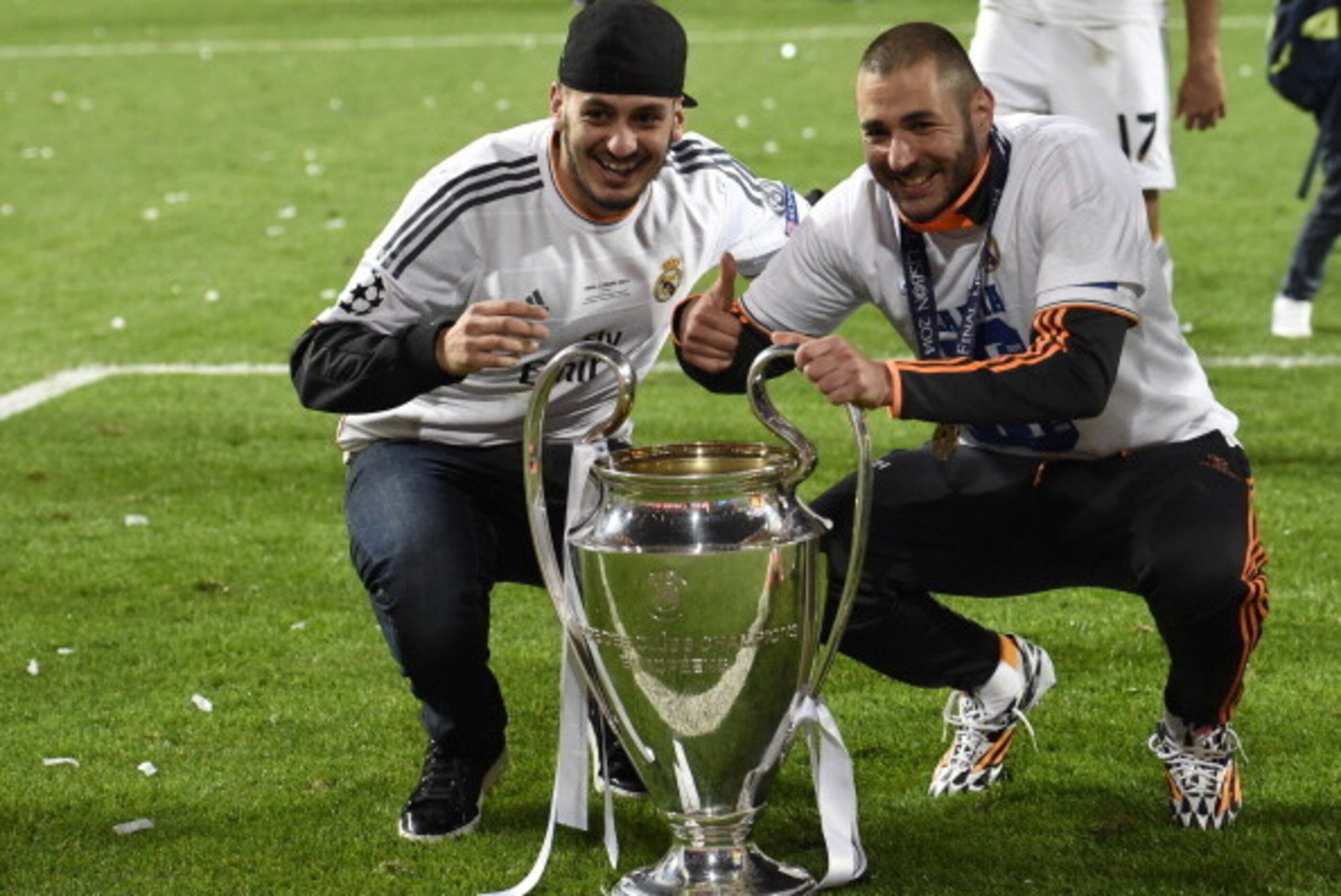 Real Madrid's French forward Karim Benzema (R) and a guest pose with the trophy at the end of the UEFA Champions League Final Real Madrid vs Atletico de Madrid at Luz stadium in Lisbon, on May 24, 2014. Real Madrid won 4-1.  AFP PHOTO/ FRANCK FIFE        