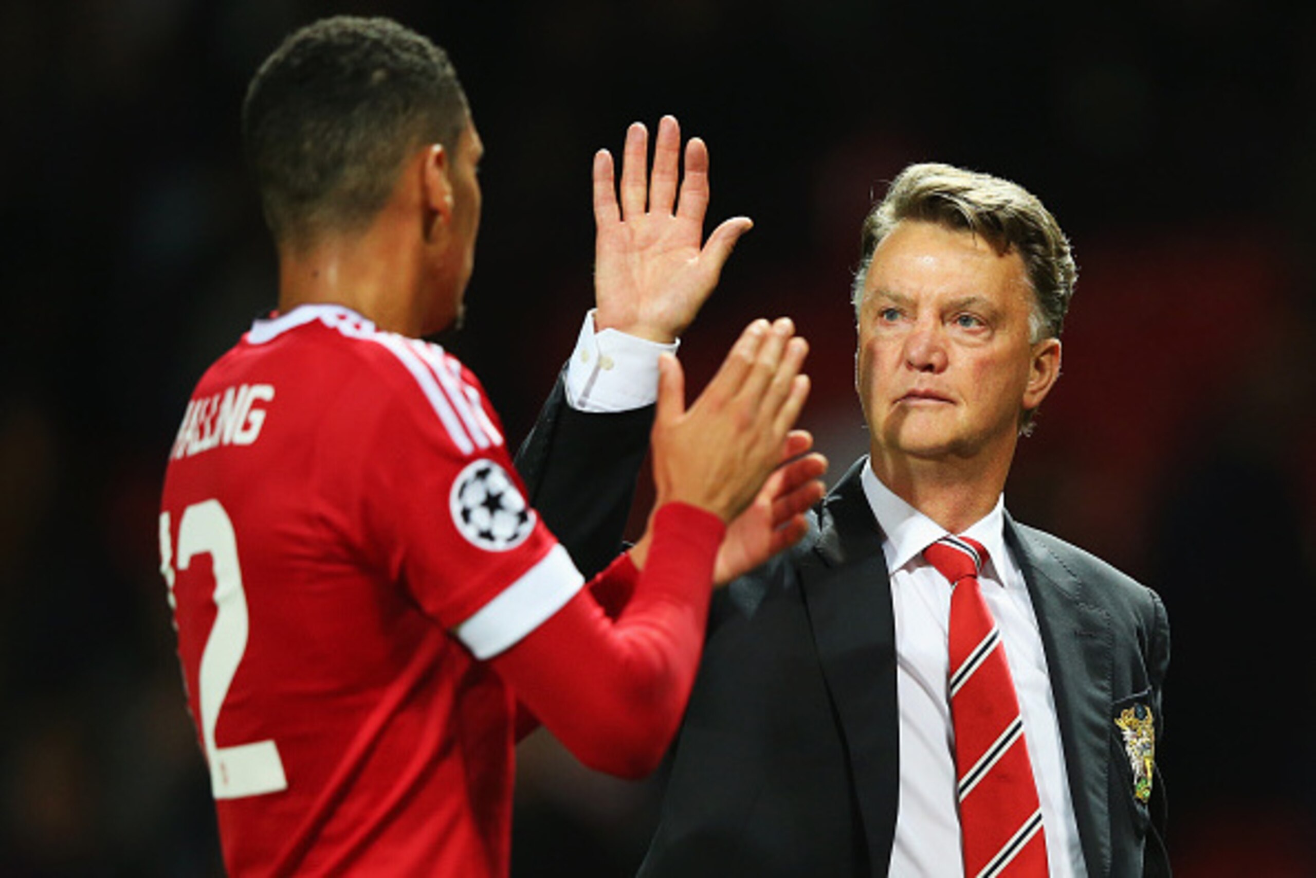 MANCHESTER, ENGLAND - AUGUST 18:  Louis van Gaal, manager of Manchester United celebrates victory with Chris Smalling after the UEFA Champions League Qualifying Round Play Off First Leg match between Manchester United and Club Brugge at Old Trafford on Au
