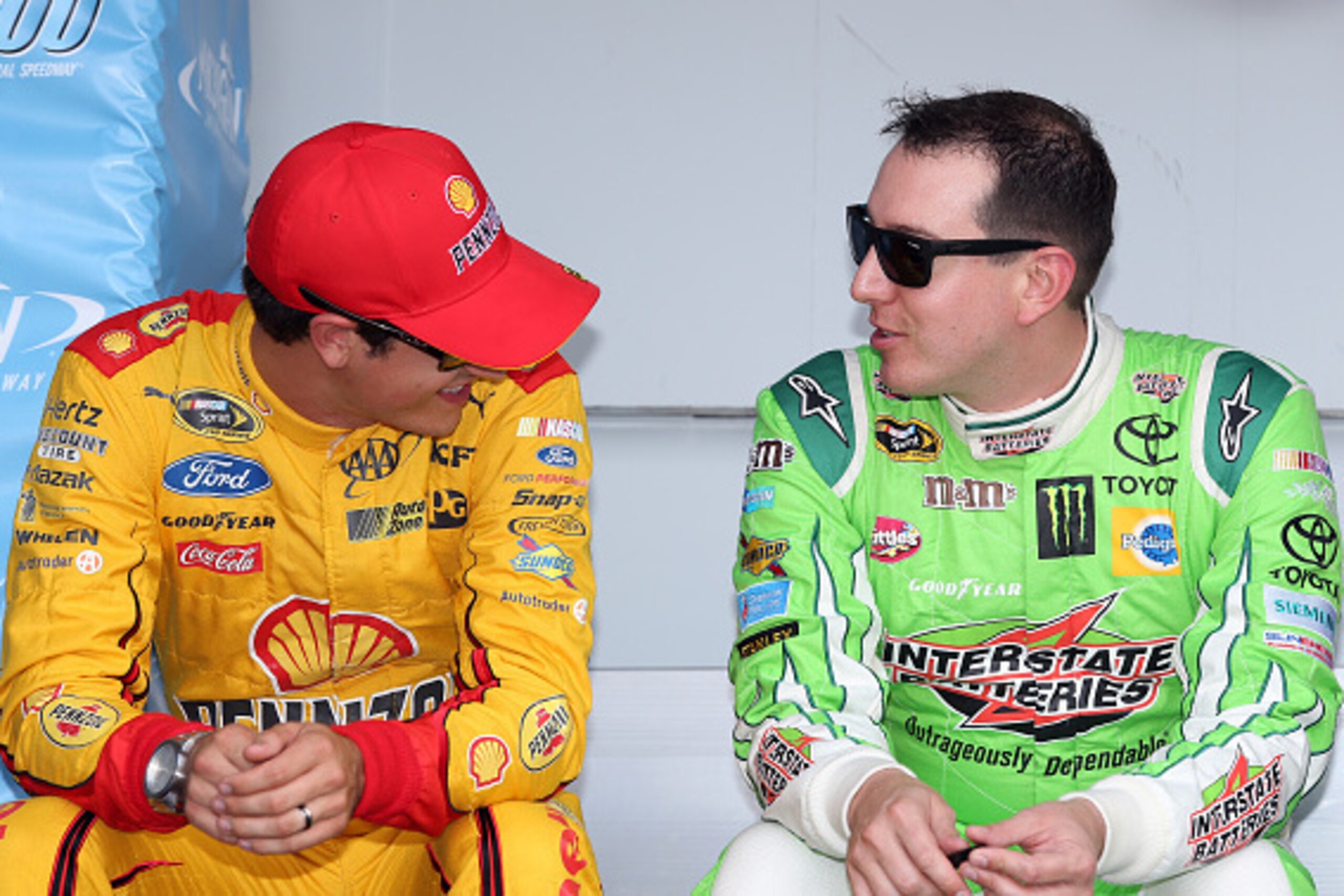 BROOKLYN, MI - AUGUST 16:  (L-R) Joey Logano, driver of the #22 Shell Pennzoil Ford, talks to Kyle Busch, driver of the #18 Interstate Batteries Toyota, before the NASCAR Sprint Cup Series Pure Michigan 400 at Michigan International Speedway on August 16,