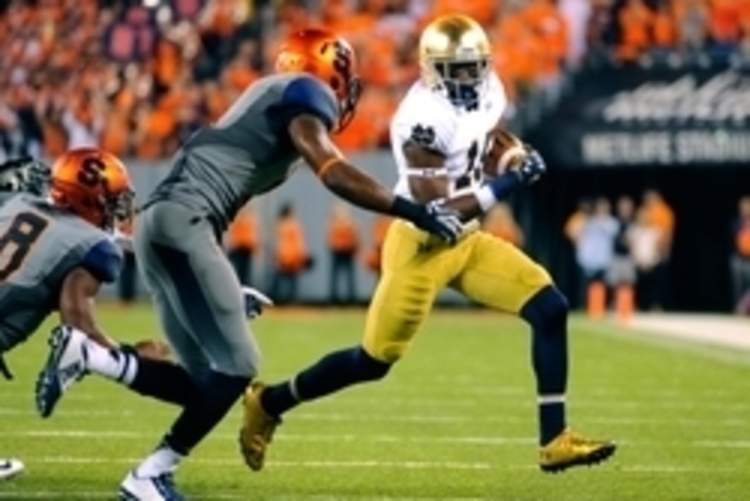 Sep 27, 2014; East Rutherford, NJ, USA; Notre Dame Fighting Irish wide receiver Torii Hunter Jr. (16) runs with the ball around Syracuse Orange safety Durell Eskridge (left) during the fourth quarter at MetLife Stadium.  Notre Dame defeated Syracuse 31-15