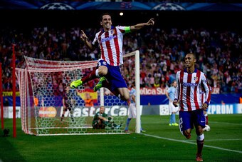 MADRID, SPAIN - OCTOBER 22: Diego Godin (L) jumps to celebrate scoring their fourth goal close to his team mate Joao Miranda (R) during the UEFA Champions League group A match between Club Atletico de Madrid and Malmo FF at Vicente Calderon stadium on Oct