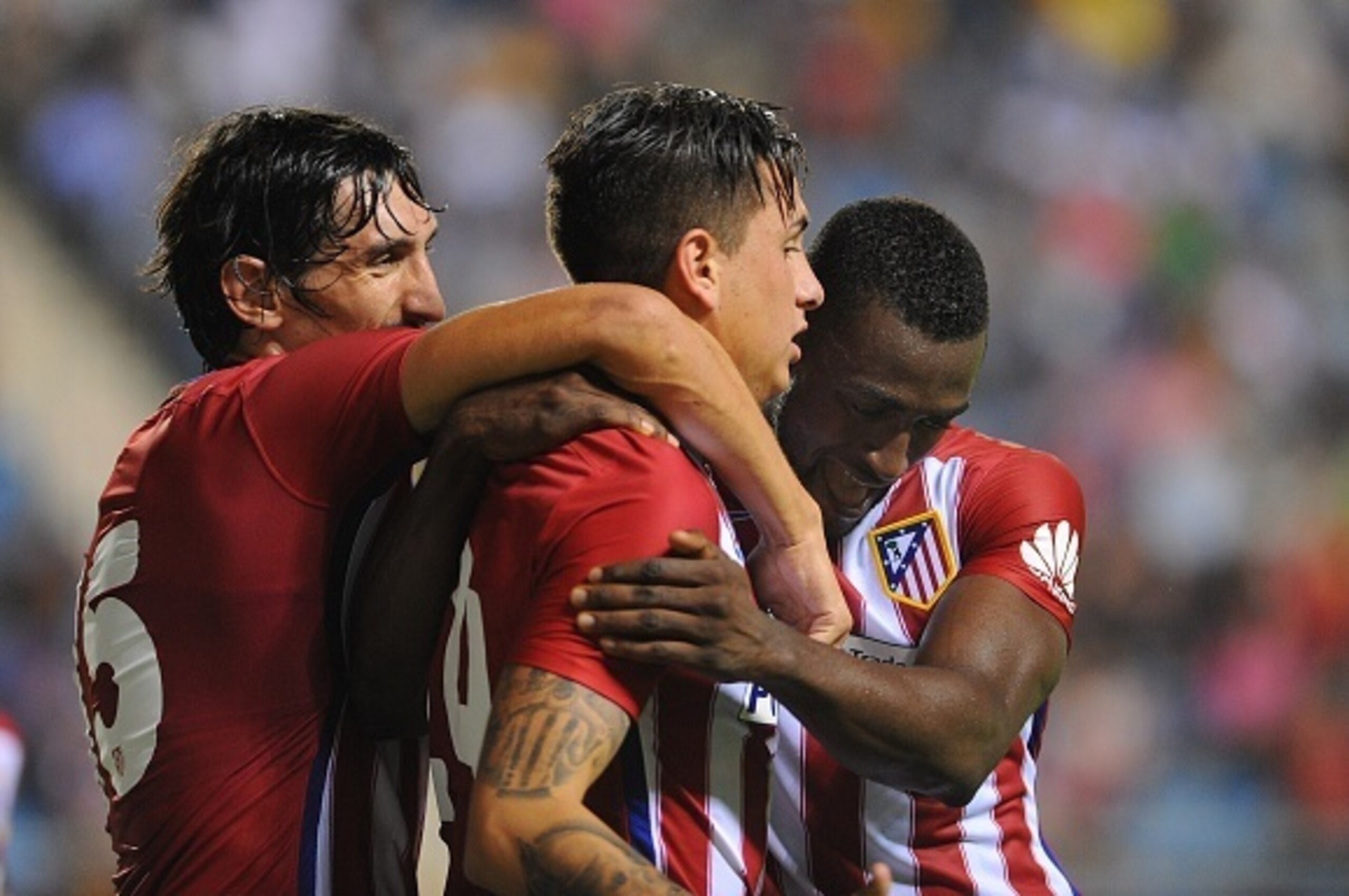 Atletico Madrid's Uruguayan defender Jose Maria Gimenez (C) celebrates after scoring with Atletico Madrid's Colombian forward  Jackson Martínez (R) and Atletico Madrid's Montenegrin defender Stefan Savic (L) during the Trofeo Carranza football match Atlet